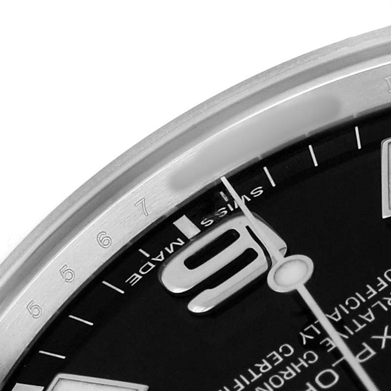 The image shows a partial view of a Rolex Explorer 214270 Men's Stainless Steel Black Dial watch, focusing on the edge of the dial and bezel with visible numerals and markers.