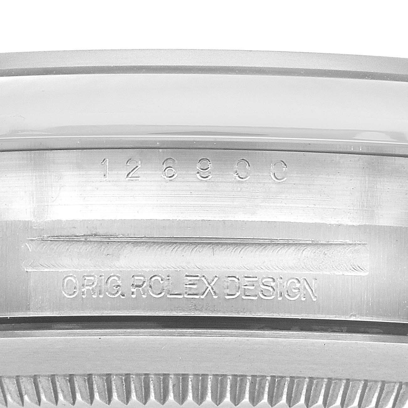 The image shows a close-up of the side of a Rolex Air-King 126900 Men's Stainless Steel Black Dial 126900 Men's Stainless Steel Black Dial with the model number and "ORIG ROLEX DESIGN" engraved.