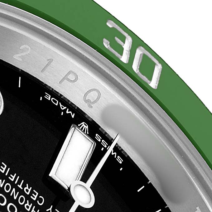 The image shows a close-up of the Submariner's bezel and part of the dial, highlighting the 30-minute marker and details like "Swiss Made."