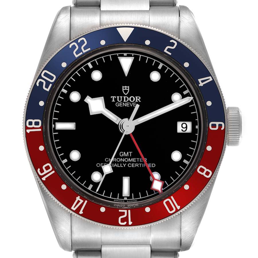 The Tudor Heritage Black Bay watch is shown from a front angle, displaying the dial, bezel, crown, and bracelet.