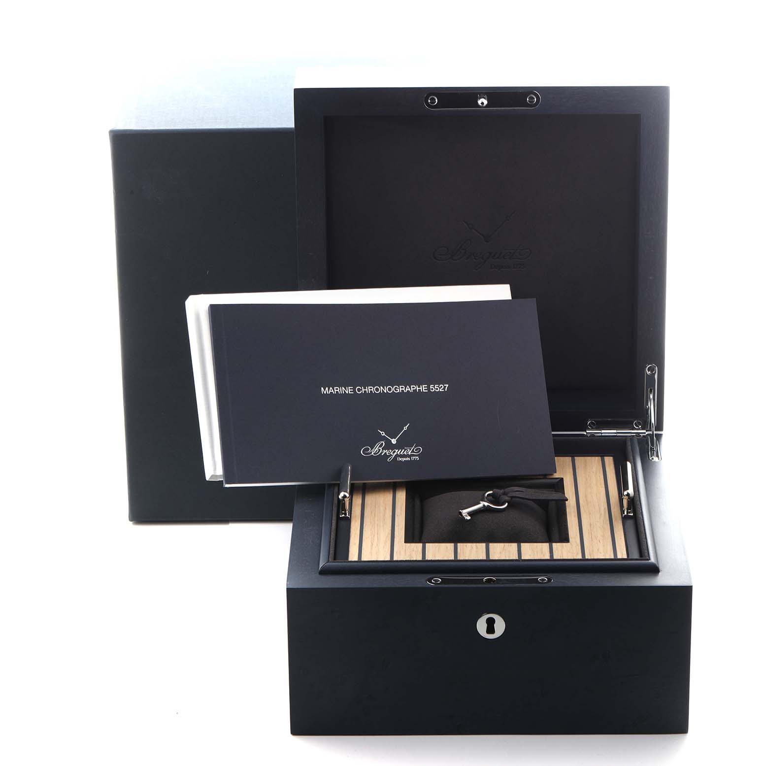 The image shows a Breguet Marine G5527I/G2/5WV Men
s Titanium Grey Dial G5527I/G2/5WV Men
s Titanium Grey Dial watch box, a manual, and a key from a top-front angle.