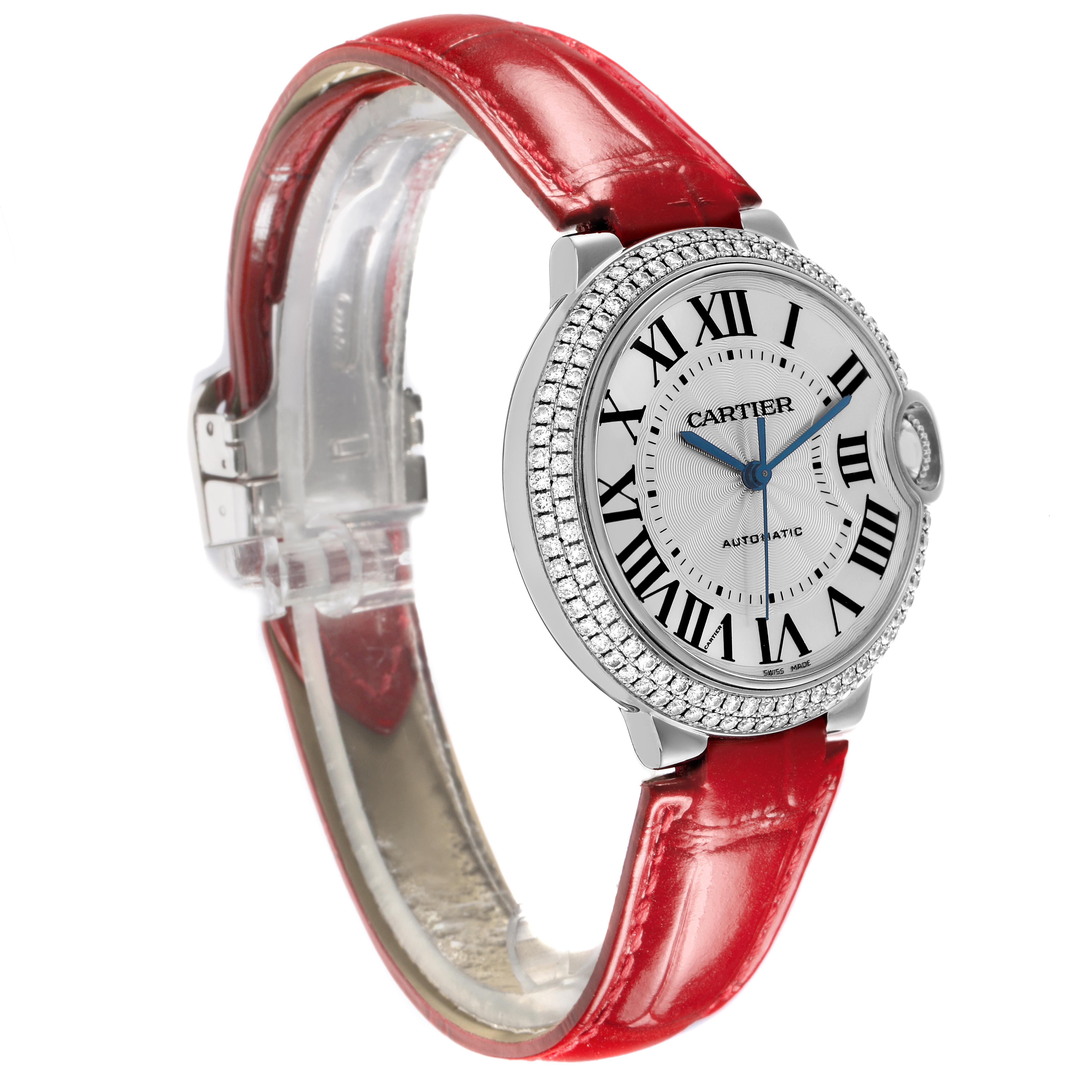 The Cartier Ballon Bleu WE900651 Women
s White Gold Silver Dial WE900651 Women
s White Gold Silver Dial watch is shown at a three-quarter angle, highlighting its round case, Roman numerals, and red strap.