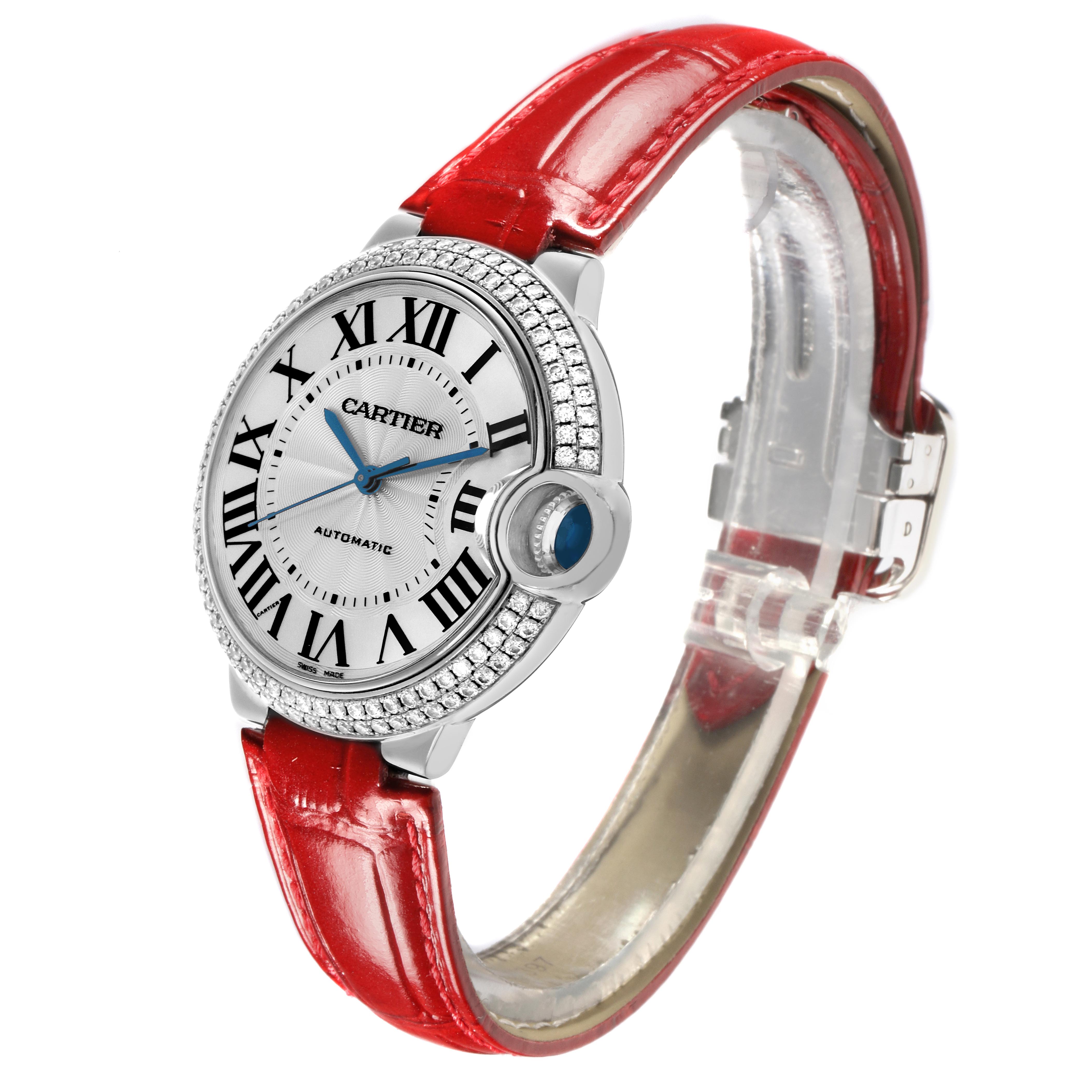 The Ballon Bleu de Cartier watch is shown at a side angle, highlighting the face, diamond-studded bezel, and red strap.