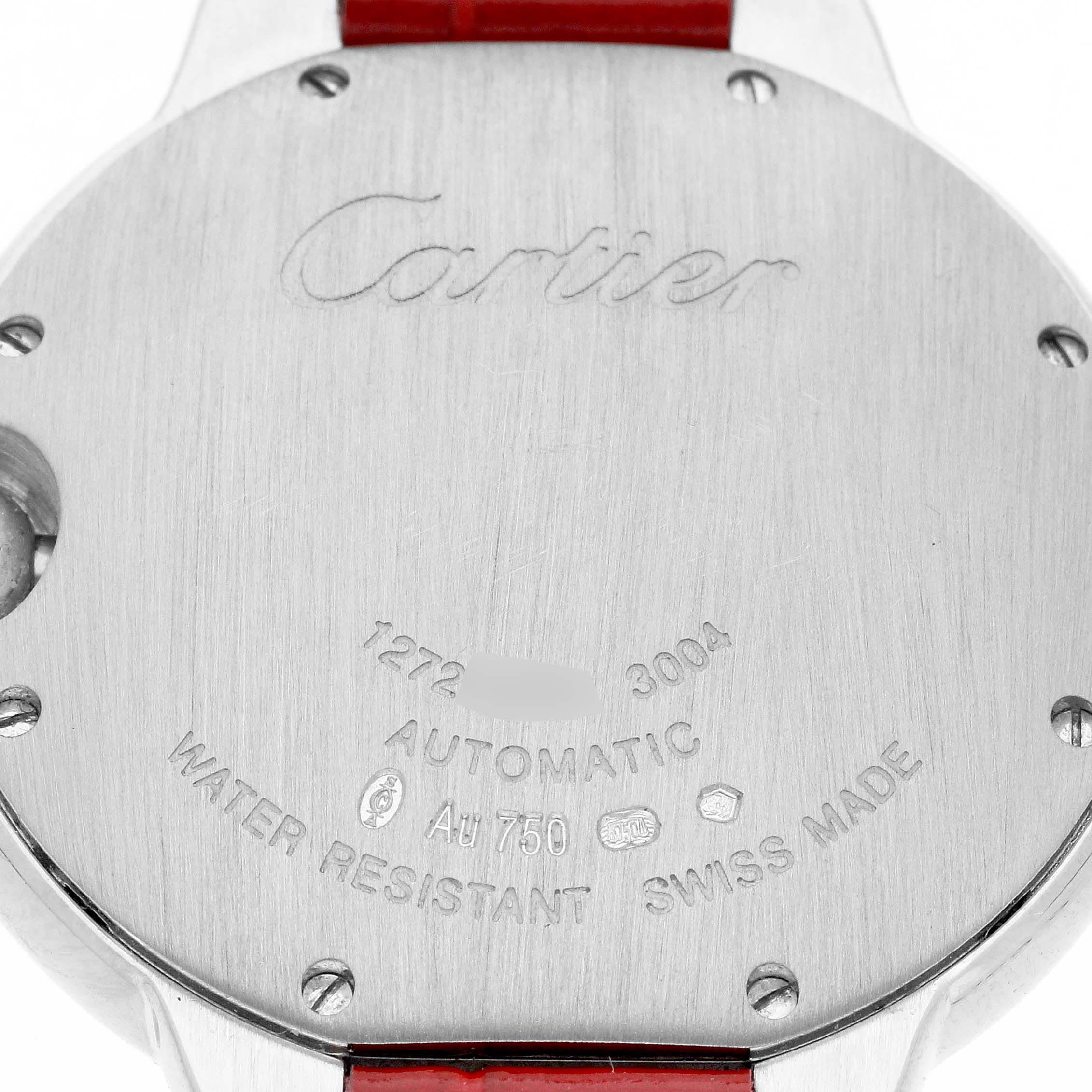 The image shows the back case of the Ballon Bleu by Cartier, featuring inscriptions and a red strap.