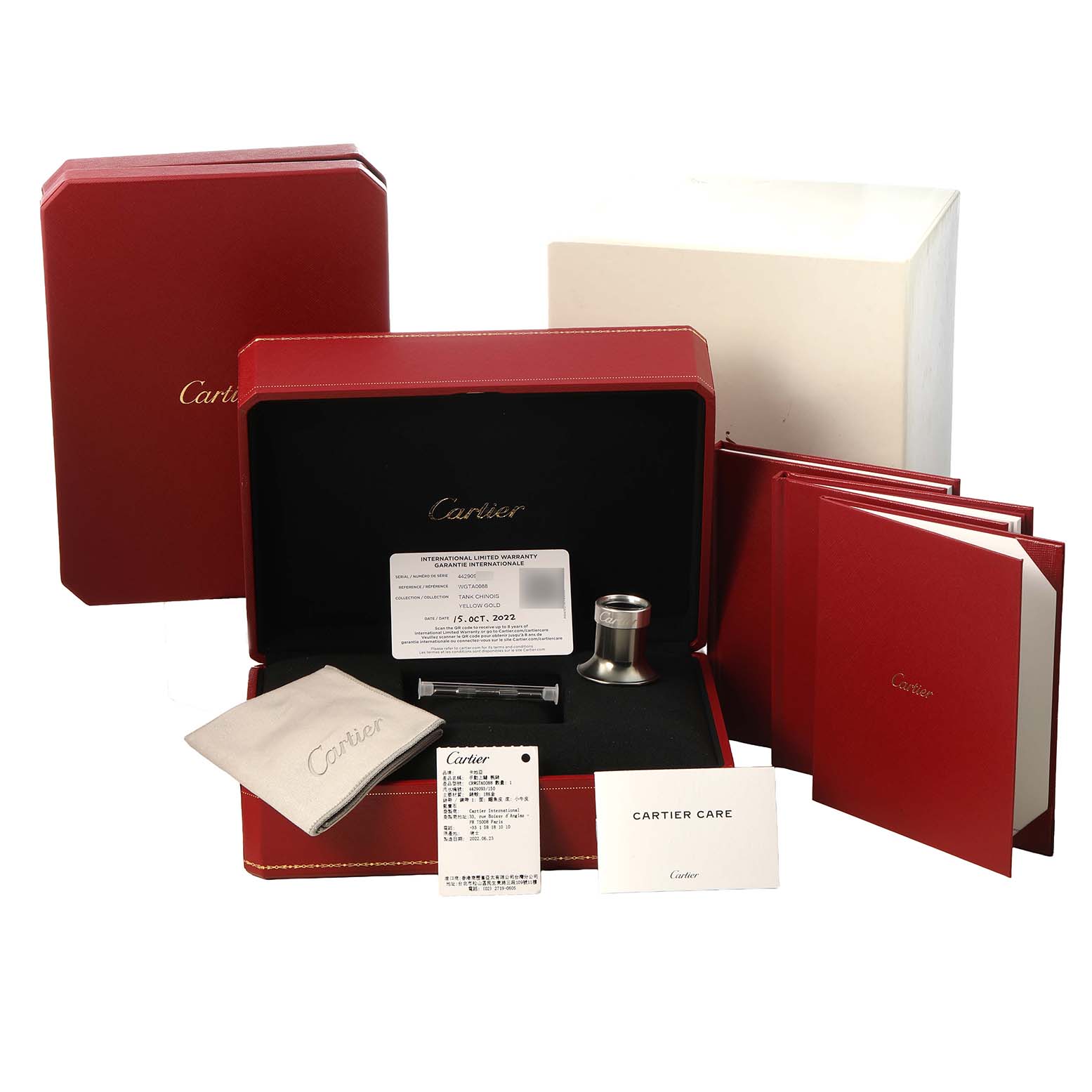 The Cartier Tank Louis WGTA0088 Men's Yellow Gold Champagne Dial watch accessories are shown from a front angle, including boxes, booklets, a polishing cloth, and warranty card.