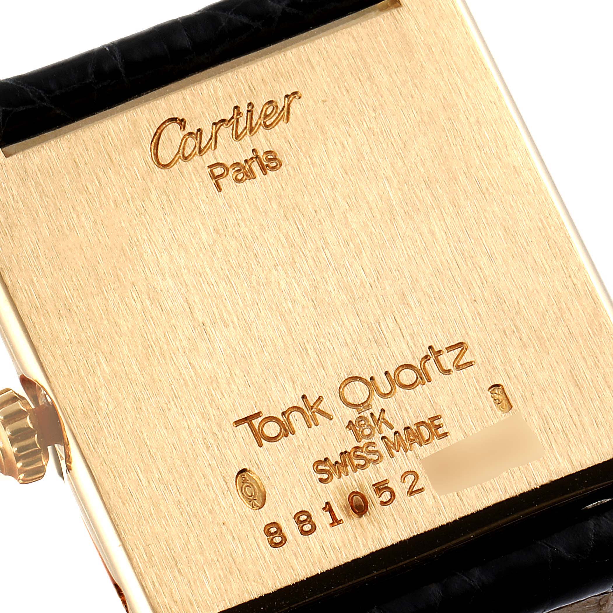 This is an angled close-up of the back of a Cartier Tank Classic Women's Yellow Gold White Dial Women's Yellow Gold White Dial watch showing the brand, model, and some specifications.