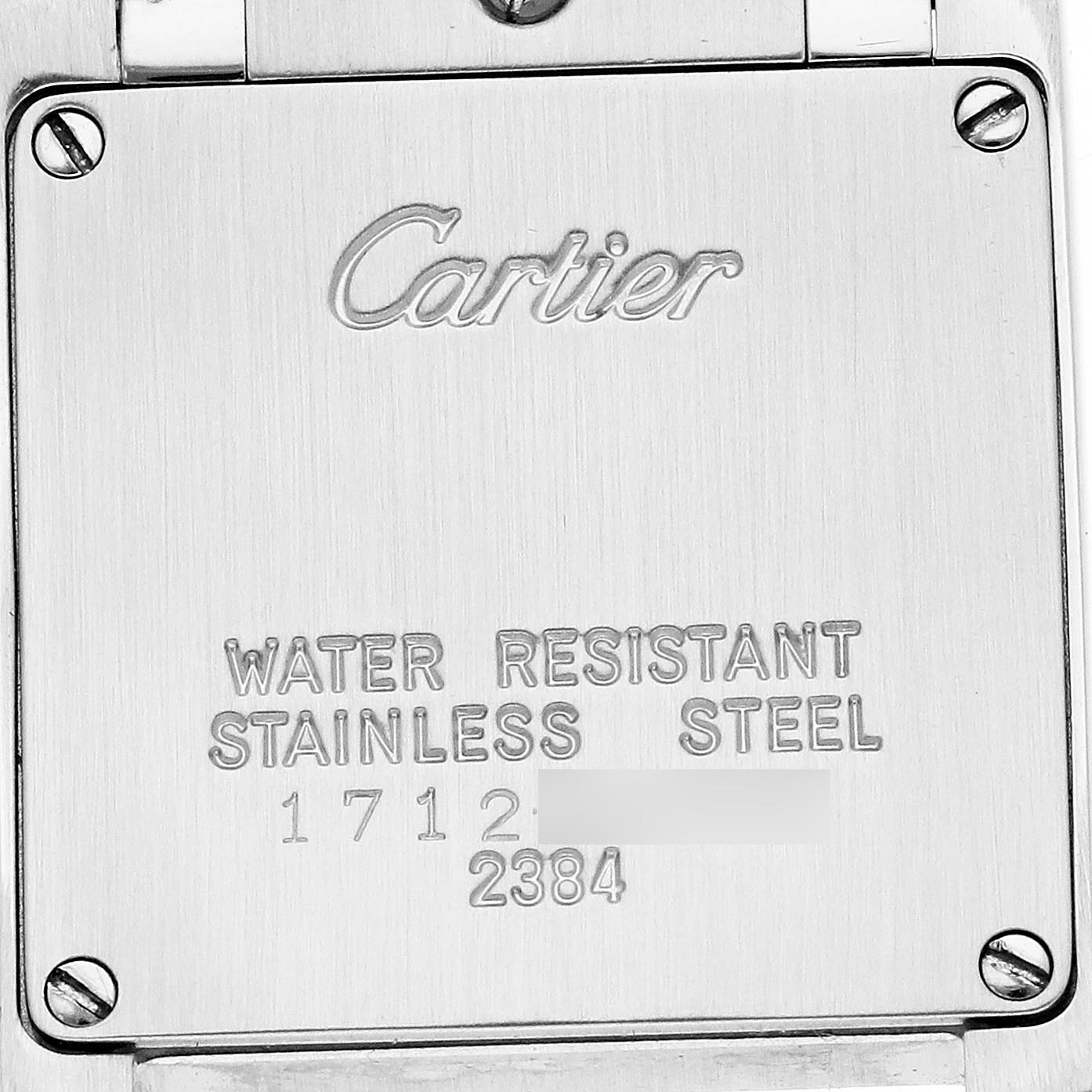 The image shows the back case of a Cartier Tank Française watch, displaying engraved text about water resistance and material.