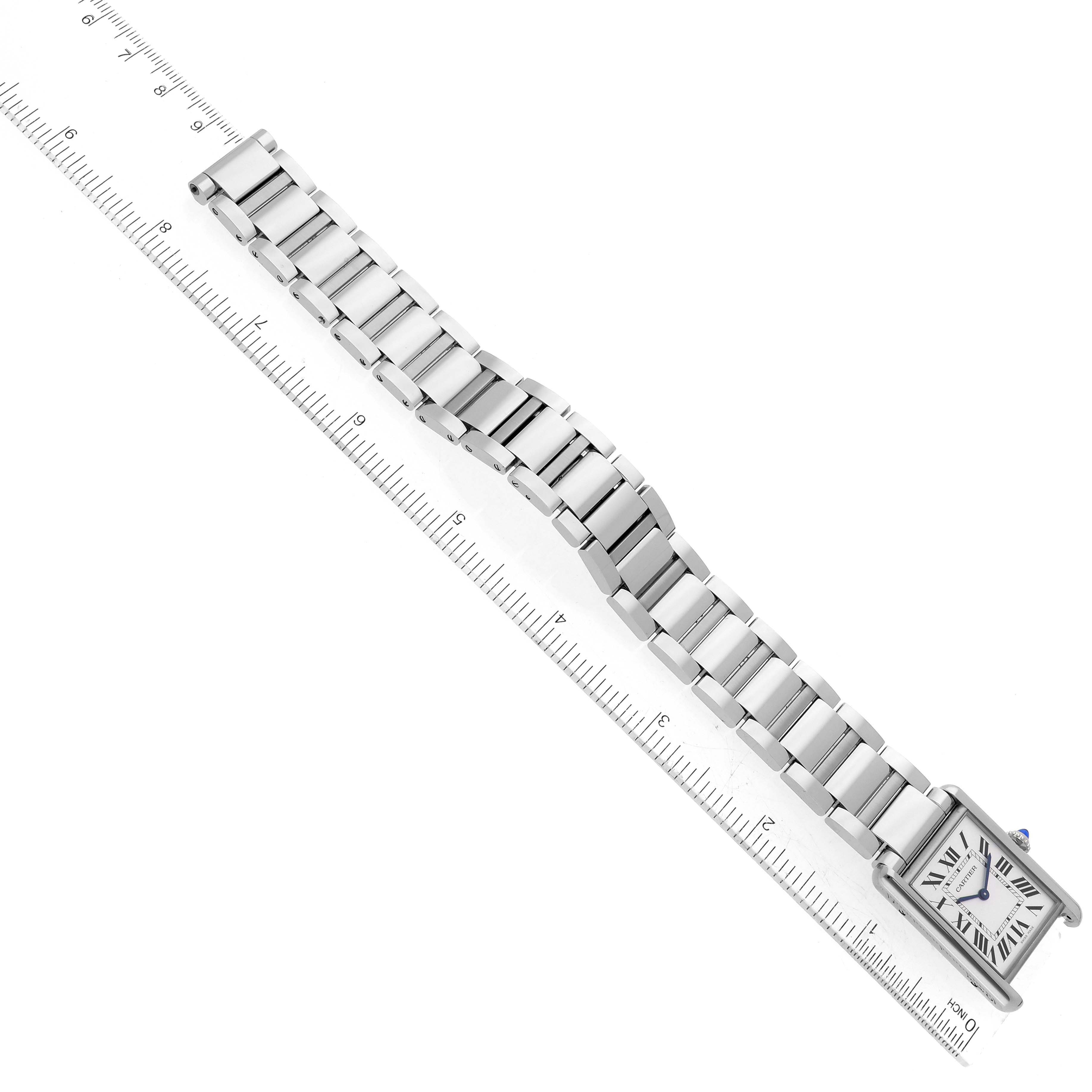 This image shows the Cartier Tank Must WSTA0052 Women's Stainless Steel Silver Dial WSTA0052 Women's Stainless Steel Silver Dial watch laid flat with a ruler beside it, highlighting its bracelet length.