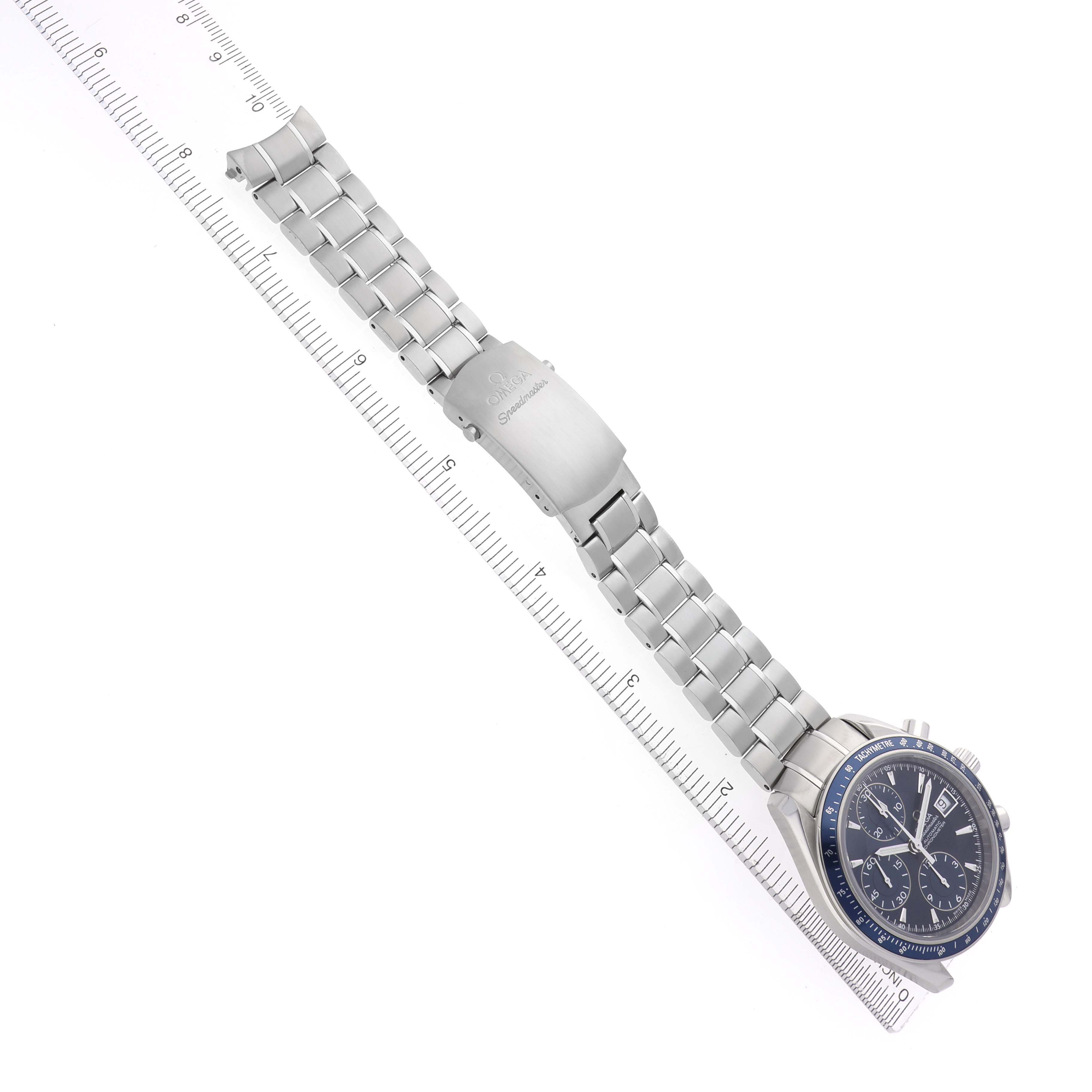 The Omega Speedmaster 3212.80.00 Men
s Stainless Steel Blue Dial 3212.80.00 Men
s Stainless Steel Blue Dial watch is shown at a slight angle displaying its face, bracelet, and clasp alongside a ruler.