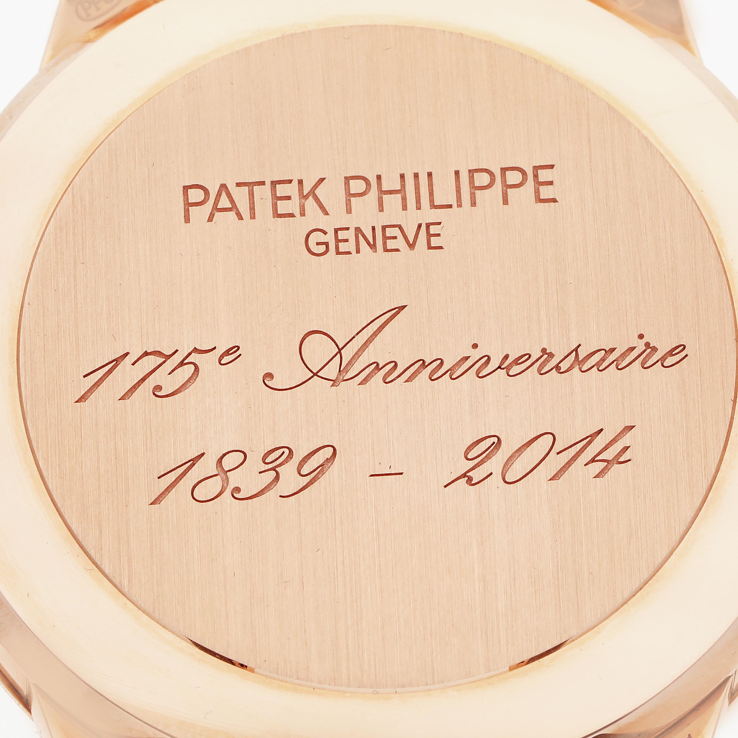 The image shows the case back of a Patek Philippe Complications 5975R-001 Men
s Rose Gold Silver Dial 5975R-001 Men
s Rose Gold Silver Dial watch, displaying engraved anniversary text.