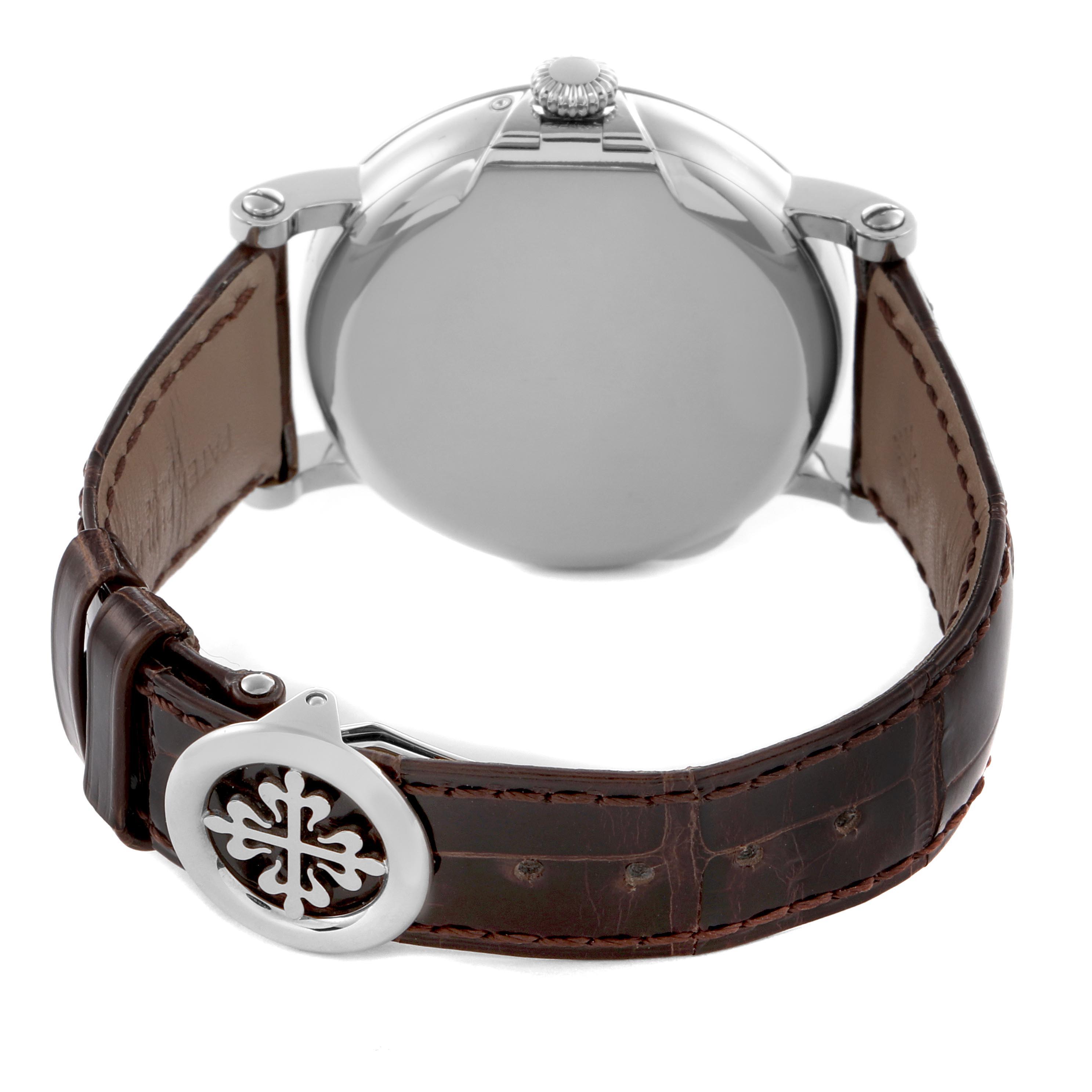 The image shows the back view of a Patek Philippe Complications 5159G-001 Men's White Gold Silver Dial 5159G-001 Men's White Gold Silver Dial watch, highlighting the case back, crown, and leather strap with emblem.