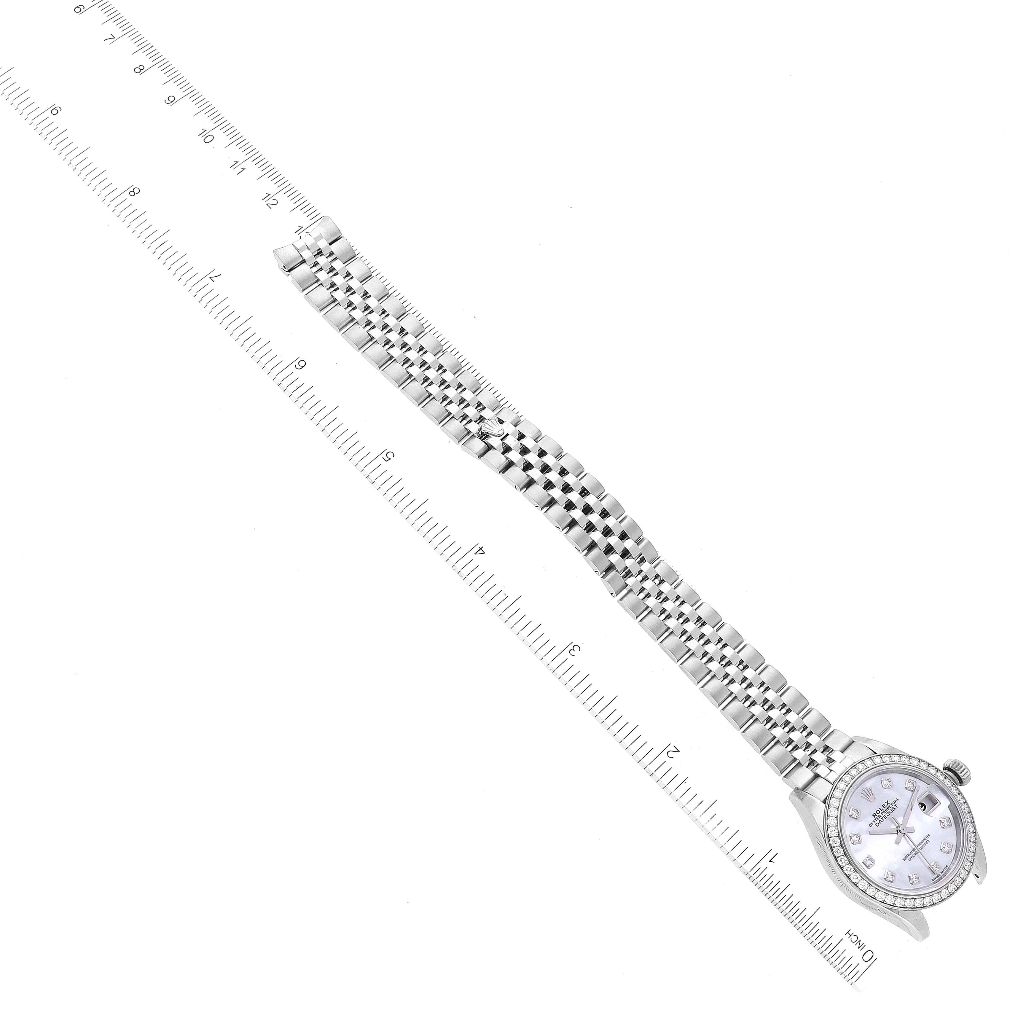 The Rolex Datejust 279384 Women's Stainless Steel Mother of Pearl Dial 279384 Women's Stainless Steel Mother of Pearl Dial watch is viewed from an overhead angle and shows the full bracelet and face next to a ruler for size reference.