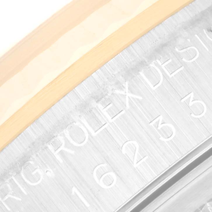The image shows a close-up of the side of the bezel and case of a Rolex Datejust 16233 Men's Steel and Gold (two tone) Black Dial 16233 Men's Steel and Gold (two tone) Black Dial watch displaying part of the model engraving.