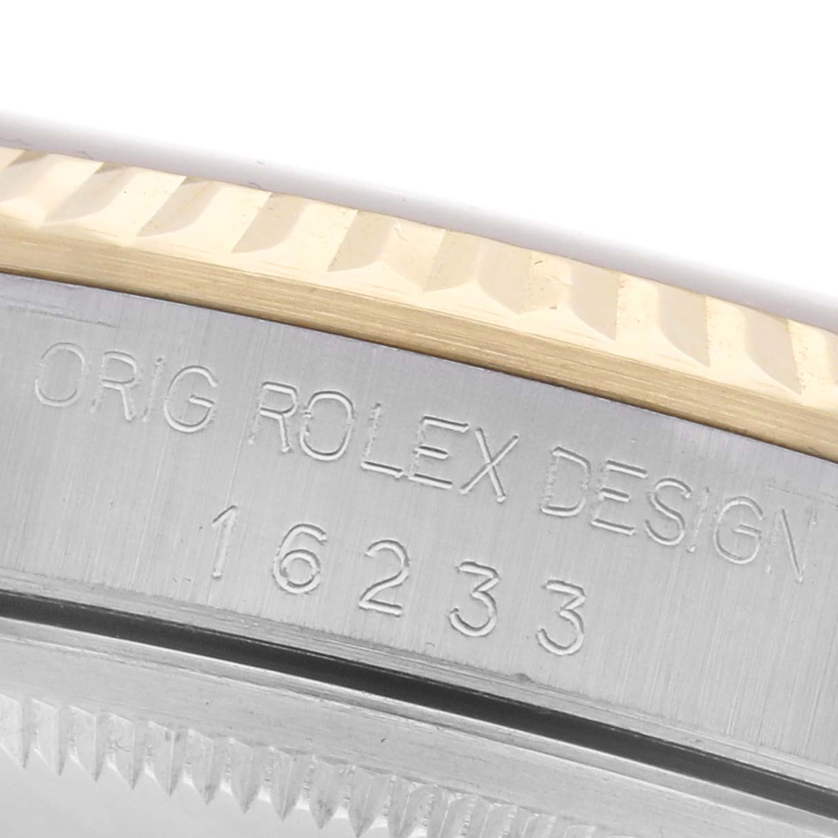 The image shows a close-up of the side of a Rolex Datejust 16233 Men
s Steel and Gold (two tone) White Dial 16233 Men
s Steel and Gold (two tone) White Dial, highlighting the engraved case details and part of the bezel.