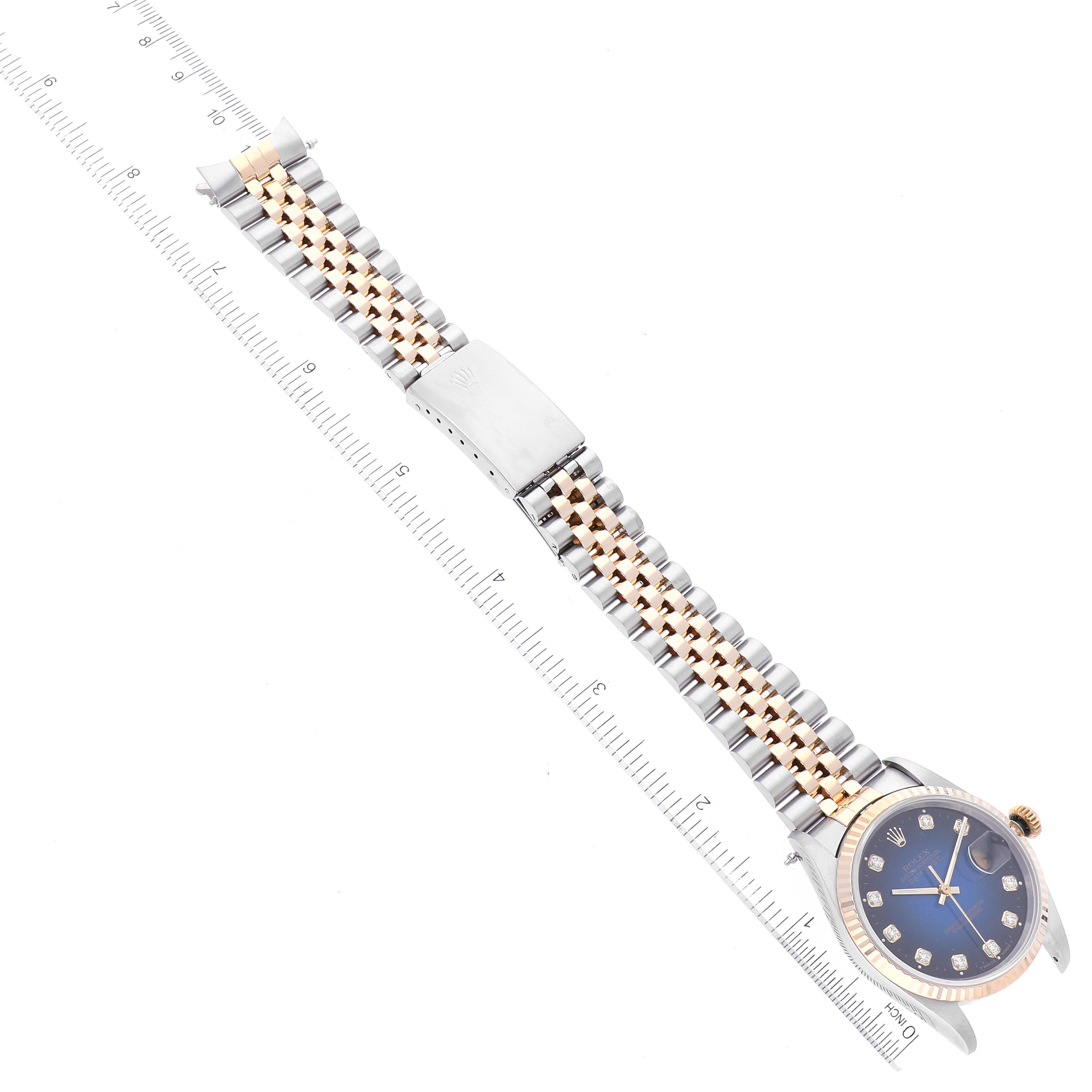 The image shows the Rolex Datejust 16233 Men's Steel and Gold (two tone) Blue Dial 16233 Men's Steel and Gold (two tone) Blue Dial watch, lying flat with the entire bracelet and face visible, with a ruler beside it for scale.