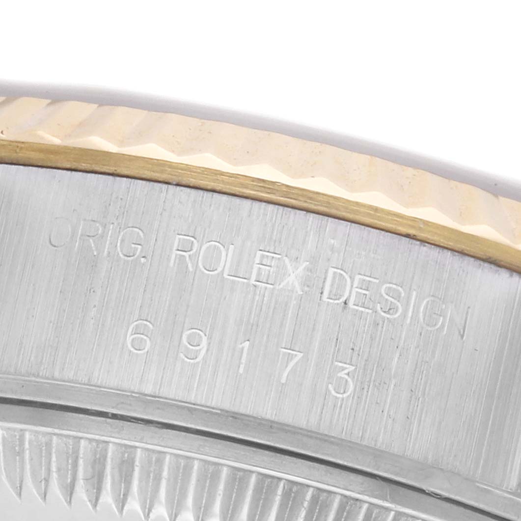 This image shows a close-up of the Rolex Datejust 69173 Women
s Steel and Gold (two tone) Champagne Dial 69173 Women
s Steel and Gold (two tone) Champagne Dial watch, focusing on the engraved side of the case with the model number.