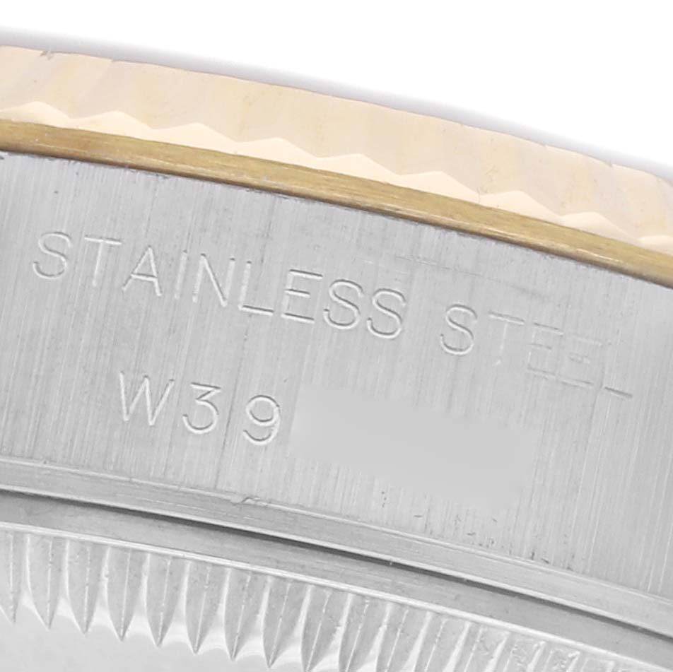 The image shows a close-up of the Rolex Datejust 69173 Women
s Steel and Gold (two tone) Champagne Dial 69173 Women
s Steel and Gold (two tone) Champagne Dial case, highlighting the stainless steel marking and part of the fluted bezel.