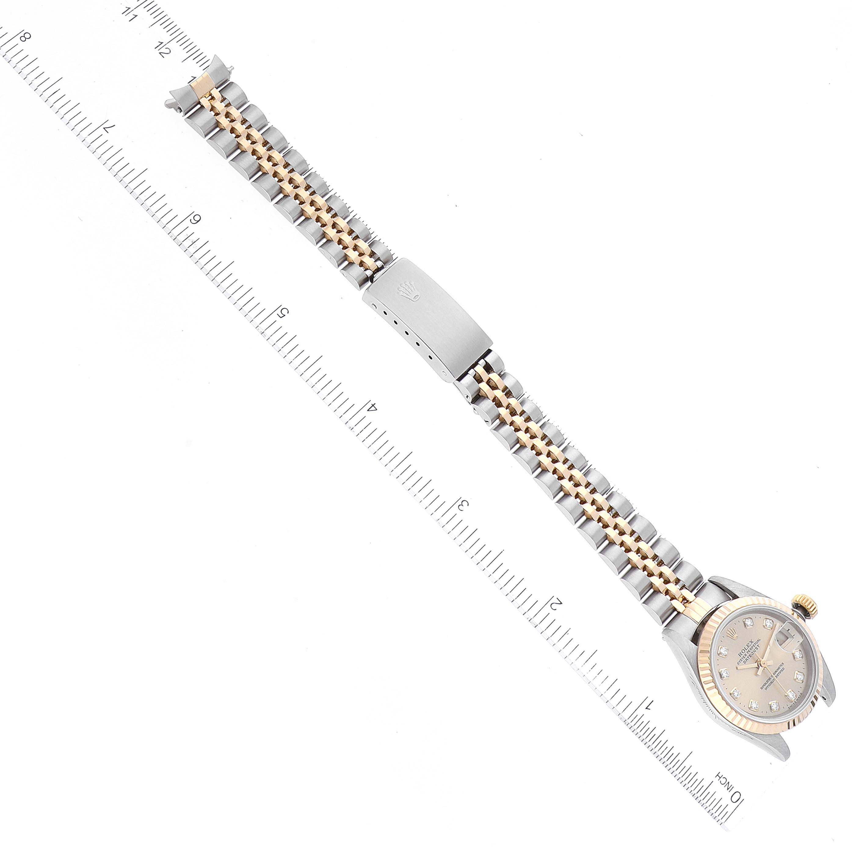 The image shows the Rolex Datejust 69173 Women's Steel and Gold (two tone) Champagne Dial 69173 Women's Steel and Gold (two tone) Champagne Dial watch from an overhead angle, featuring its band and face alongside a measuring ruler.