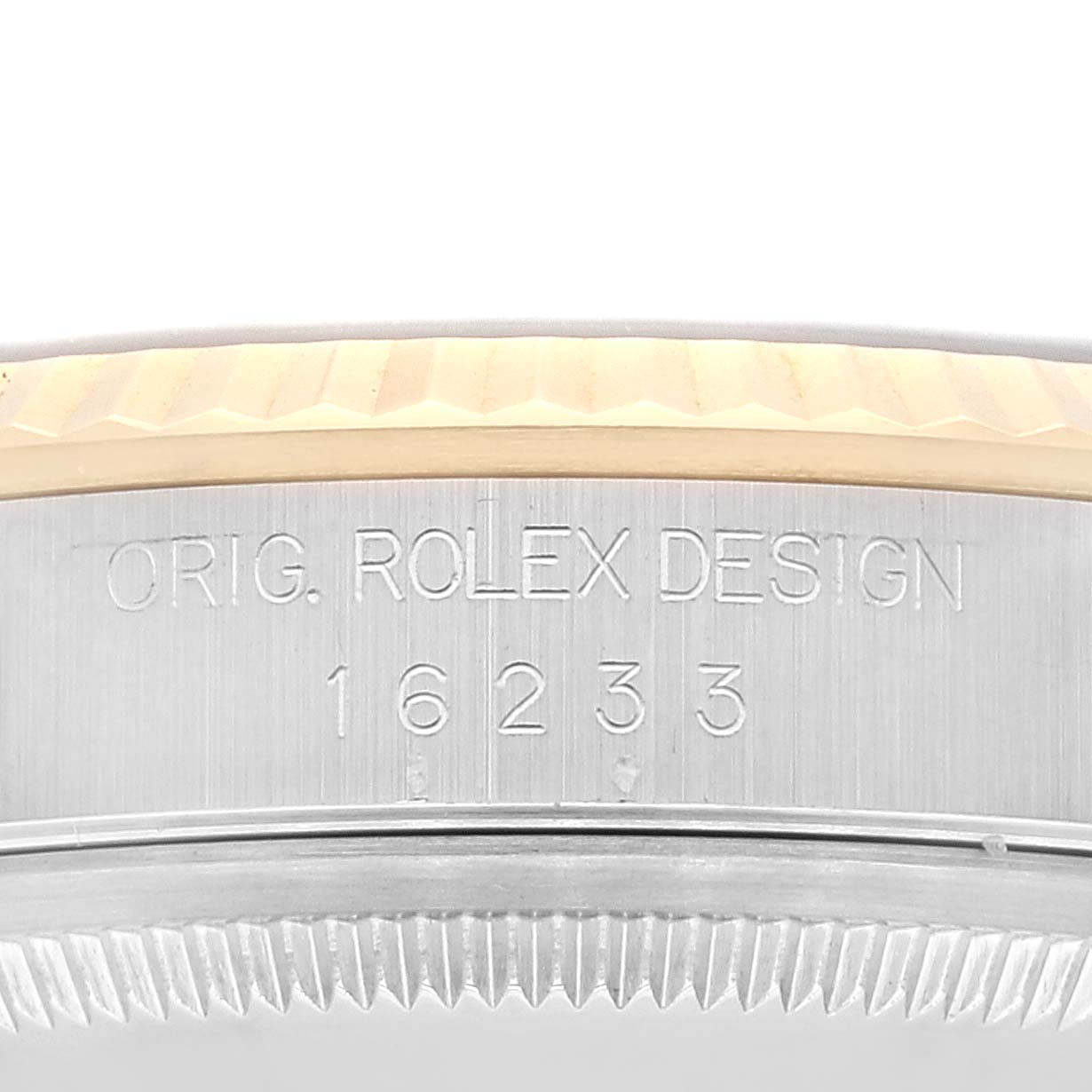 This close-up image shows the edge and side of the bezel and case of the Rolex Datejust 16233 Men's Steel and Gold (two tone) Blue Dial 16233 Men's Steel and Gold (two tone) Blue Dial 16233, displaying the engraved design markings.