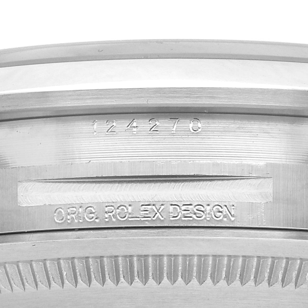 The image shows a close-up of the side of a Rolex Explorer 124270 Men
s Stainless Steel Black Dial 124270 Men
s Stainless Steel Black Dial watch case with model number 124270 and "ORIG. ROLEX DESIGN" engraving.