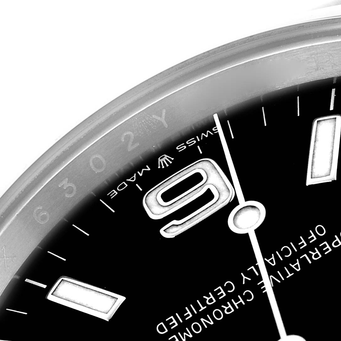 This close-up image of the Rolex Explorer 124270 Men
s Stainless Steel Black Dial 124270 Men
s Stainless Steel Black Dial watch shows part of the dial, bezel, and the number 9 prominently.