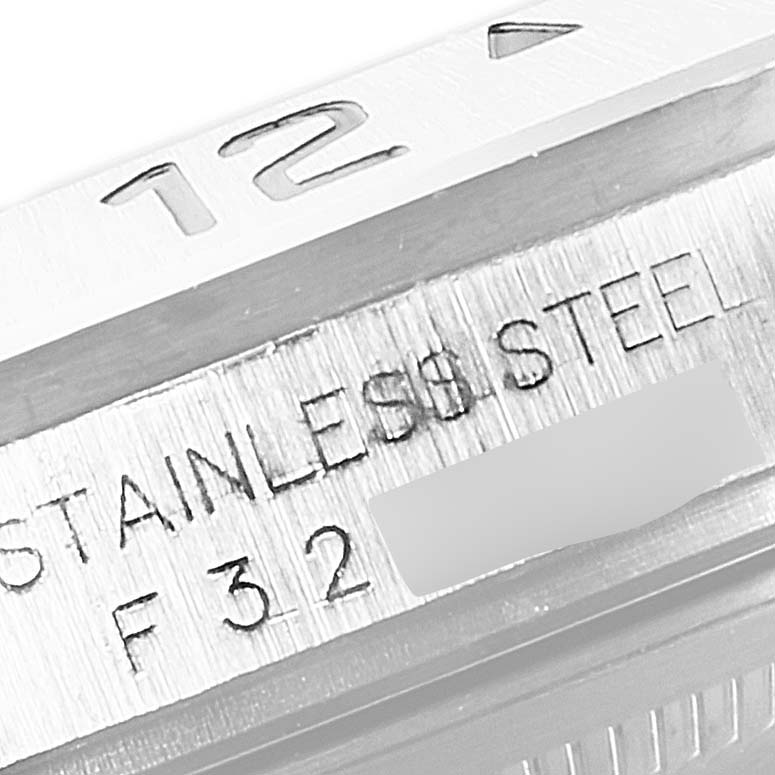 The image shows a close-up of the side of the bezel and case of a Rolex Explorer 16570 Men's Stainless Steel Black Dial 16570 Men's Stainless Steel Black Dial watch, highlighting the "12" marker and "STAINLESS STEEL" engraving.