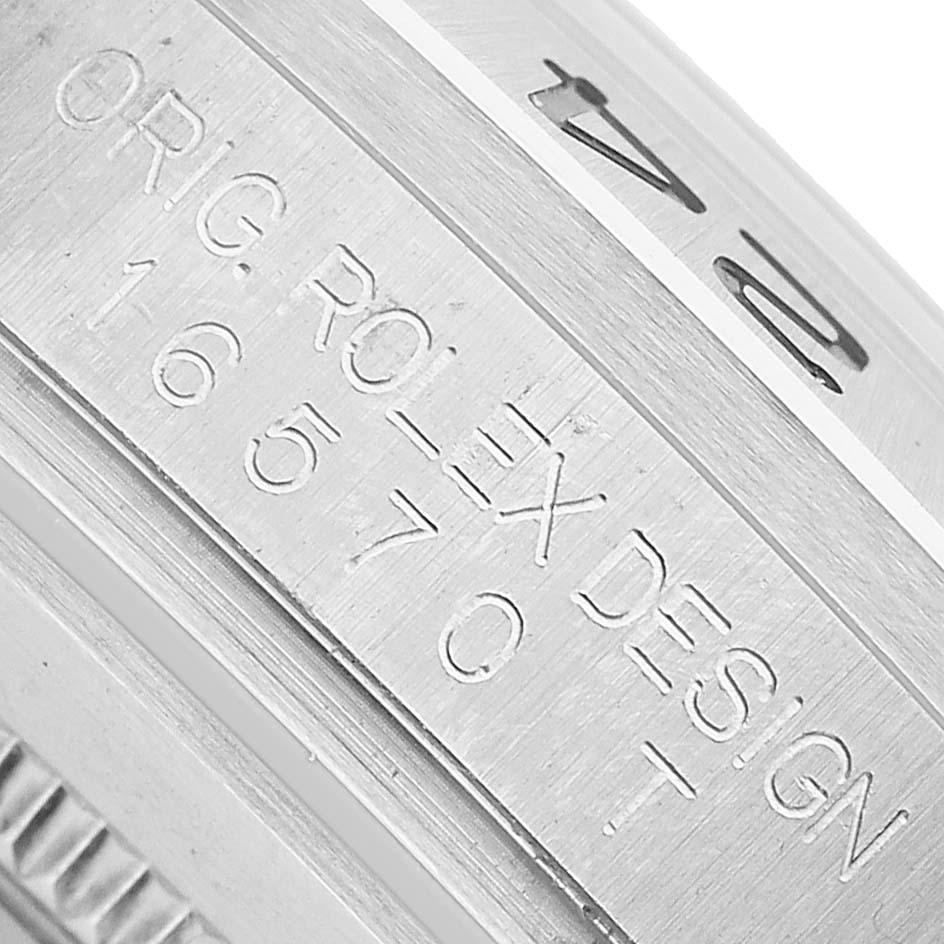 The image shows a close-up of the bezel and casing side of a Rolex Explorer 16570 Men's Stainless Steel White Dial, with engraved model details.