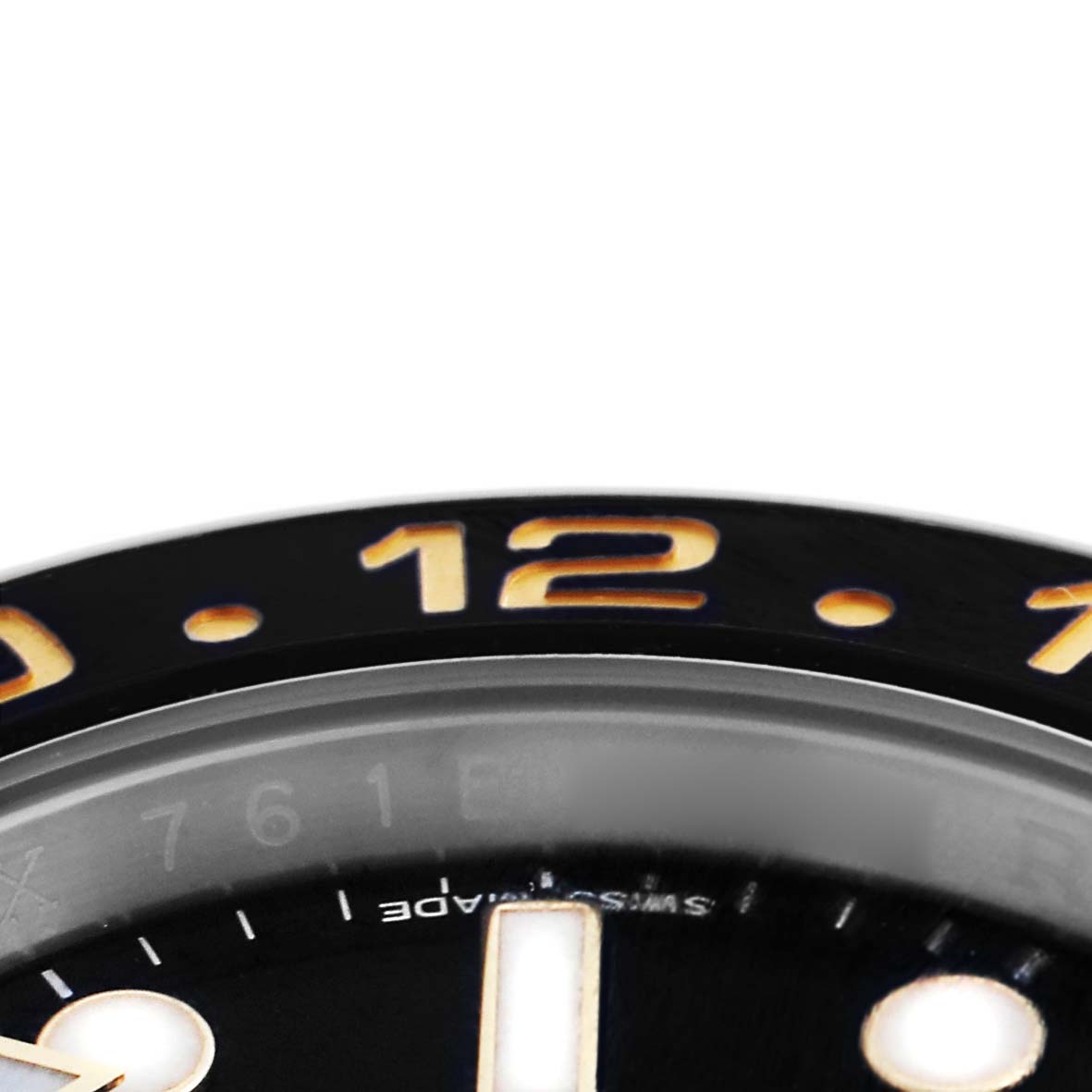 The image shows a close-up of the bezel and part of the dial of the Rolex GMT-Master 116713LN Men
s Steel and Gold (two tone) Black Dial 116713LN Men
s Steel and Gold (two tone) Black Dial, highlighting the "12" marker.