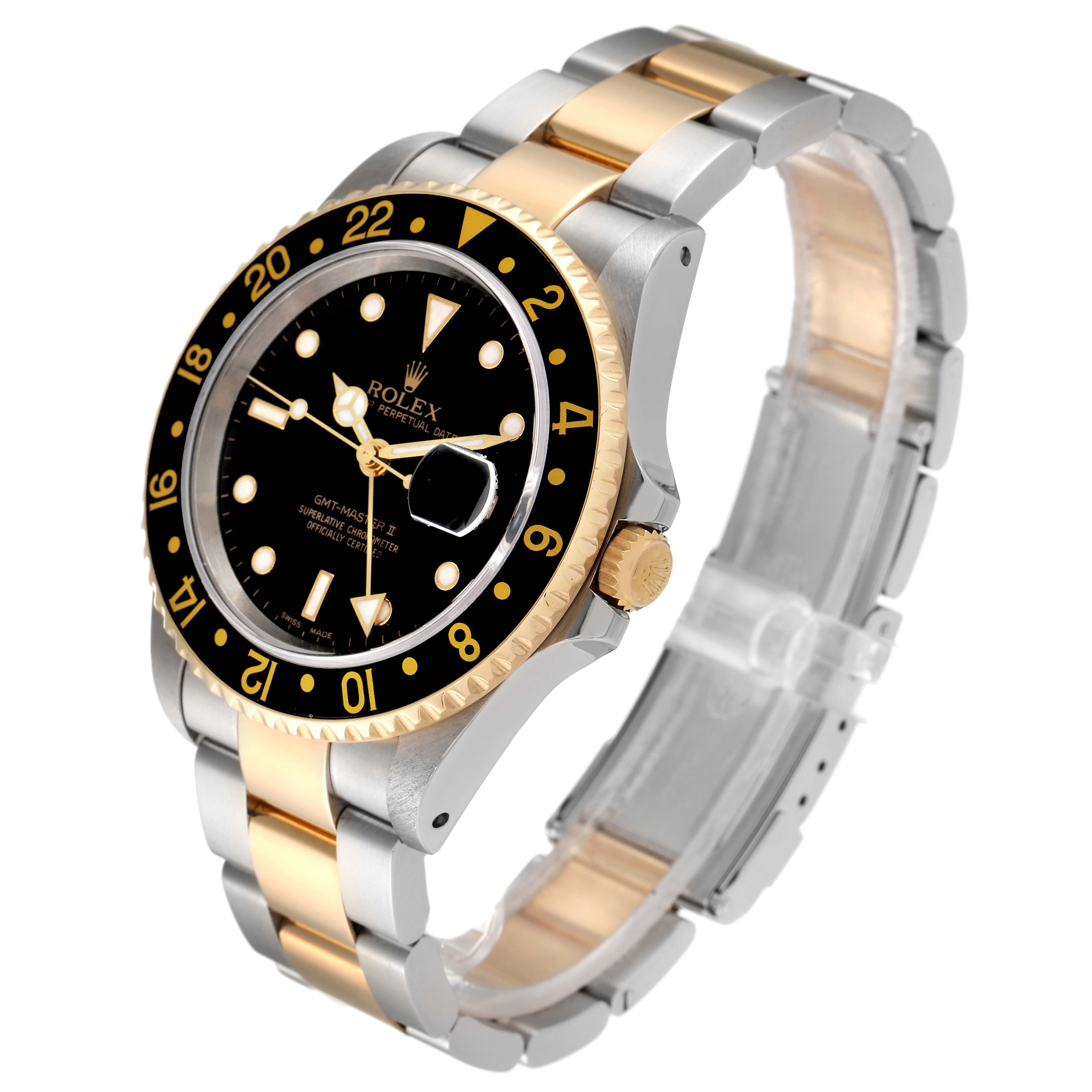 The Rolex GMT-Master 16713 Men's Steel and Gold (two tone) Black Dial 16713 Men's Steel and Gold (two tone) Black Dial watch is shown at an angled view, highlighting its black dial, gold bezel, and two-tone gold and silver bracelet.