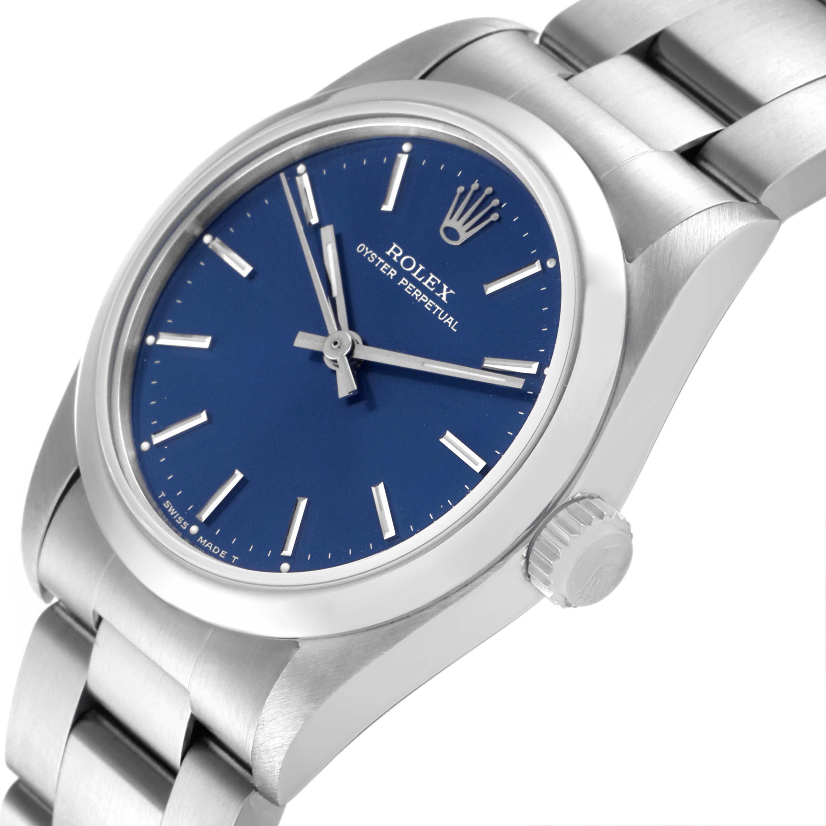 The Mid-Size Rolex watch features a close-up side angle, showing the blue dial, crown, and part of the metal bracelet.