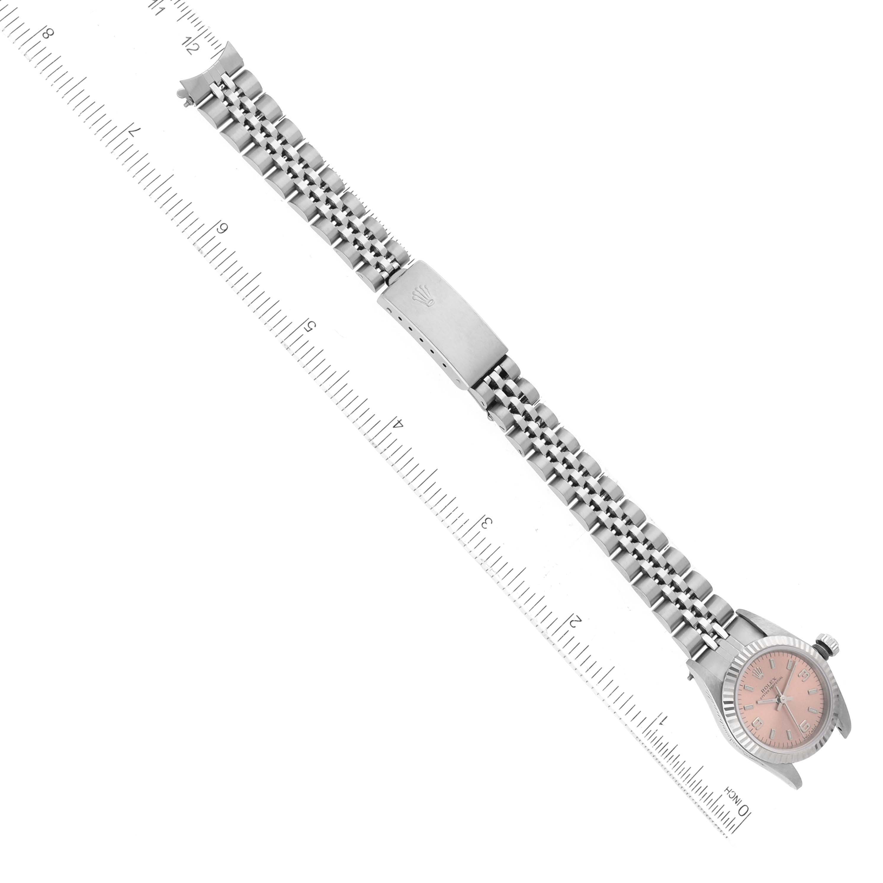 The image shows a Rolex Oyster Perpetual 76094 Women's Stainless Steel Pink Dial 76094 Women's Stainless Steel Pink Dial watch laid flat, displaying its bracelet, clasp, and face beside a ruler for scale.