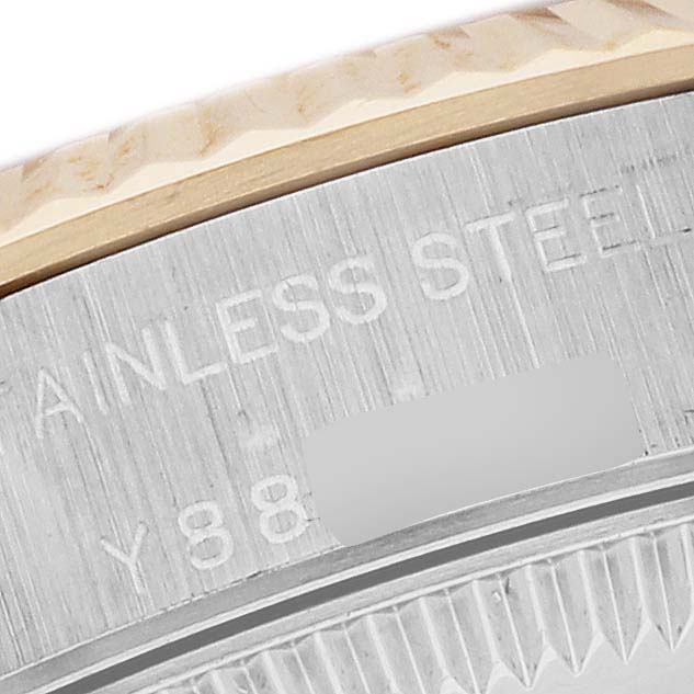 This close-up image shows the stainless steel back and part of the fluted bezel of a Rolex Oyster Perpetual 76193 Women's Steel and Gold (two tone) Silver Dial 76193 Women's Steel and Gold (two tone) Silver Dial watch.