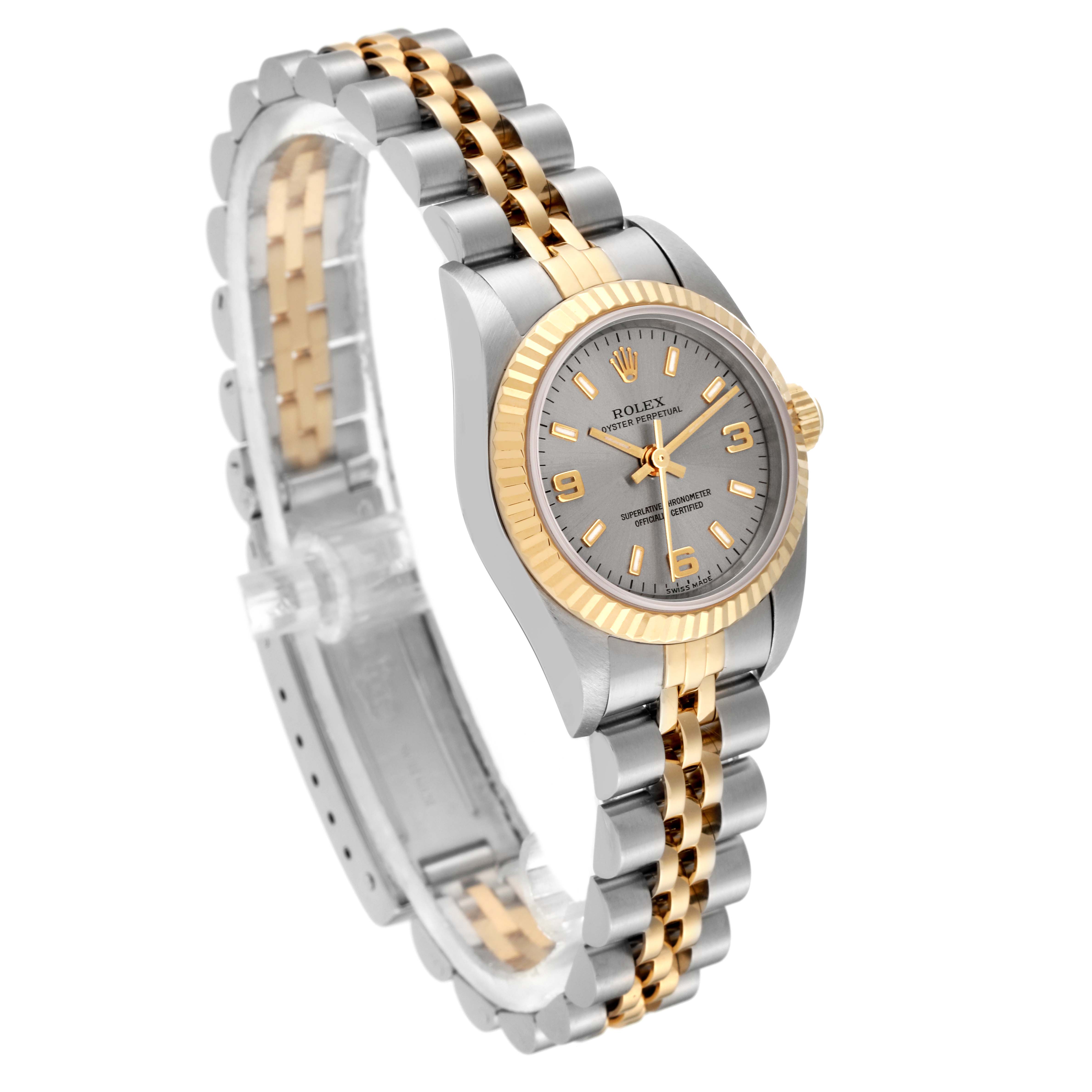The Rolex Oyster Perpetual 76193 Women's Steel and Gold (two tone) Silver Dial 76193 Women's Steel and Gold (two tone) Silver Dial watch is shown at an angled side view, displaying its two-tone bracelet, dial, and fluted bezel.