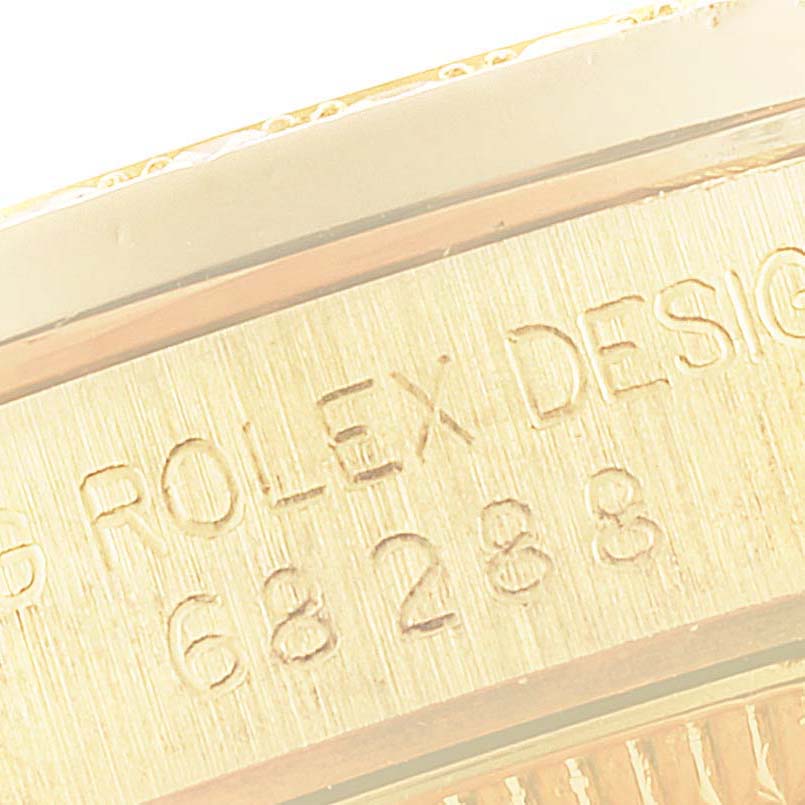 The image shows a close-up view of the Rolex President 68288 Women
s Yellow Gold Champagne Dial 68288 Women
s Yellow Gold Champagne Dial model, focusing on the engraved serial number and design markings.