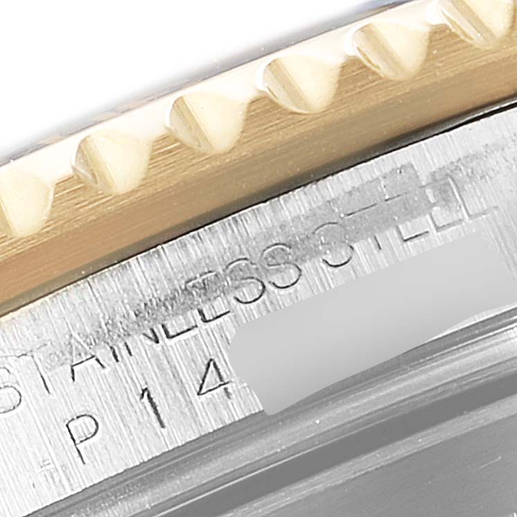 The image shows a close-up view of the edge and bezel teeth of a Rolex Submariner 16613 Men
s Steel and Gold (two tone) Black Dial 16613 Men
s Steel and Gold (two tone) Black Dial watch with part of its model and stainless steel inscription visible.