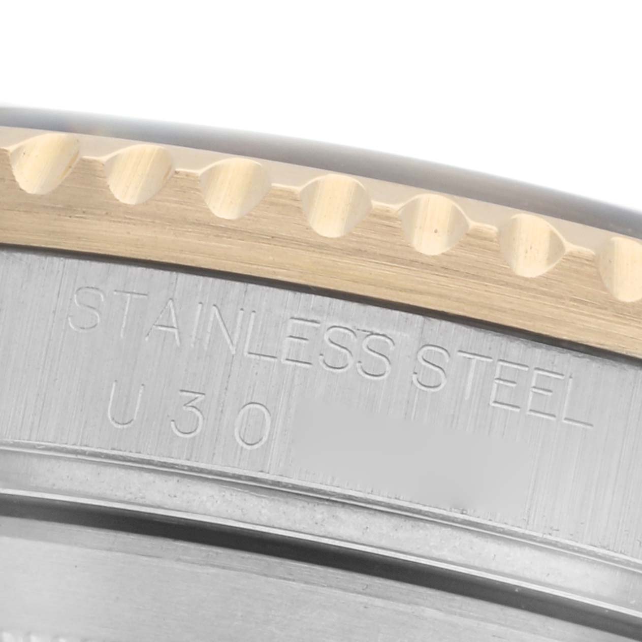 The image shows a close-up of the side of a Rolex Submariner 16613 Men
s Steel and Gold (two tone) Black Dial 16613 Men
s Steel and Gold (two tone) Black Dial
s bezel, featuring the "STAINLESS STEEL" engraving.