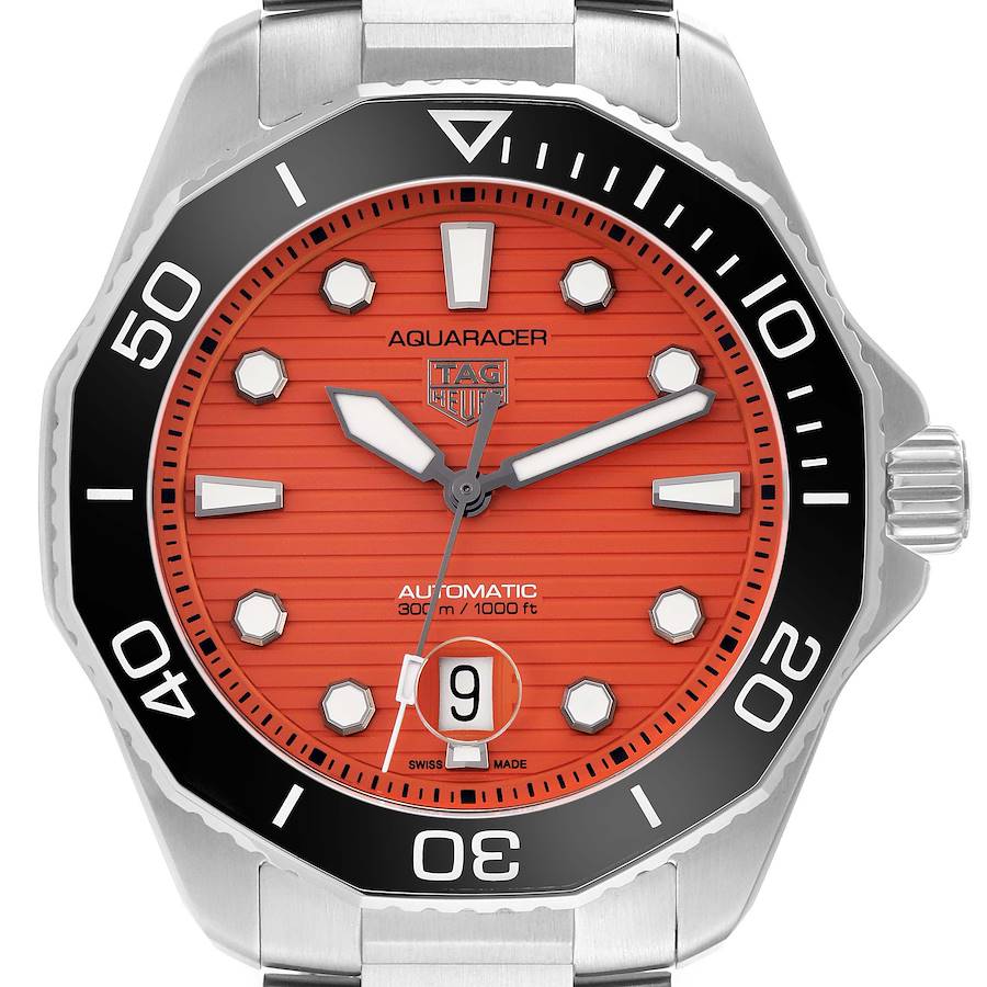 The TAG Heuer Aquaracer is shown from a front angle, highlighting the red dial, bezel, hands, and date window.