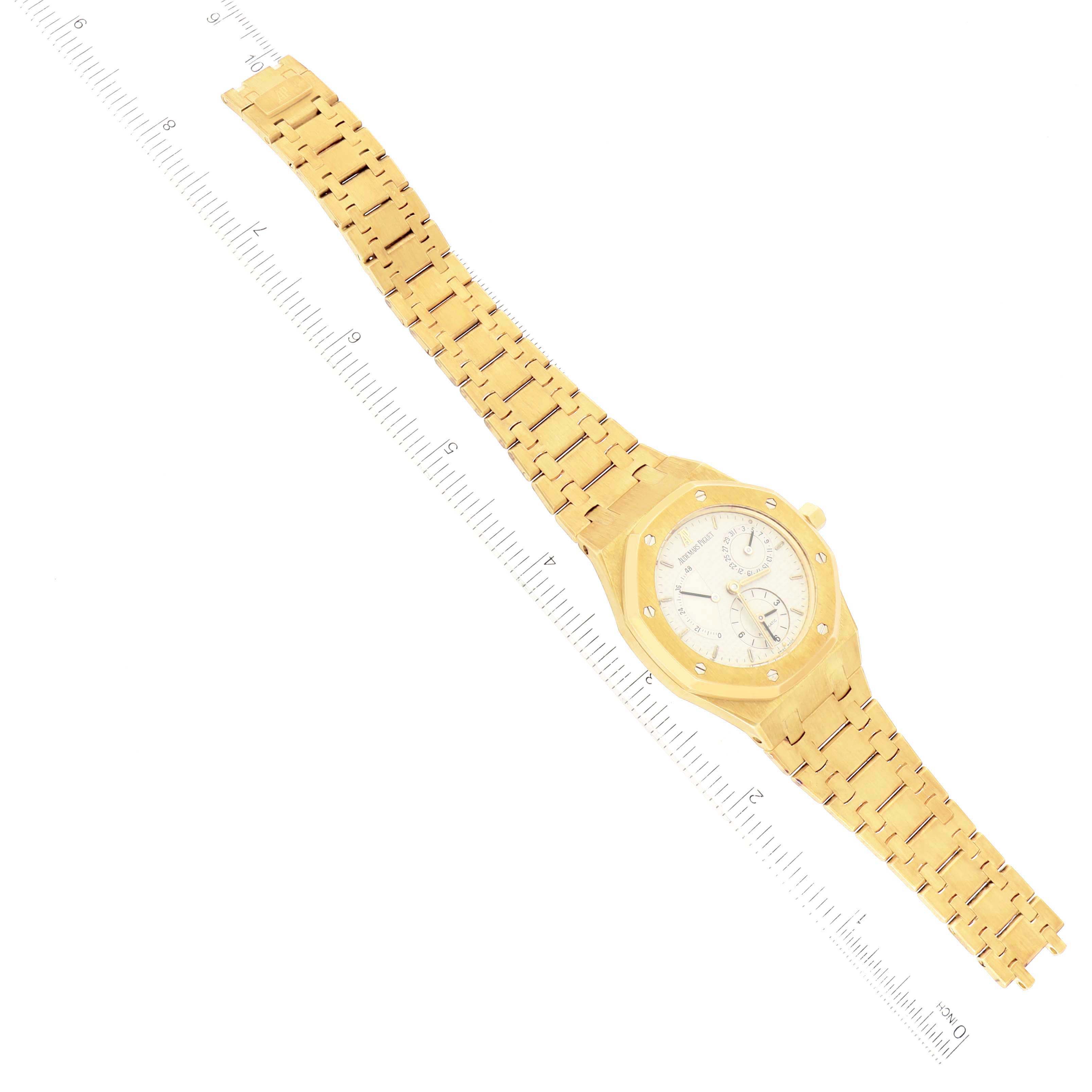 The image shows an overhead view of an Audemars Piguet Royal Oak 25730BA Men's Yellow Gold Silver Dial 25730BA Men's Yellow Gold Silver Dial watch with a ruler measuring the length of the bracelet.