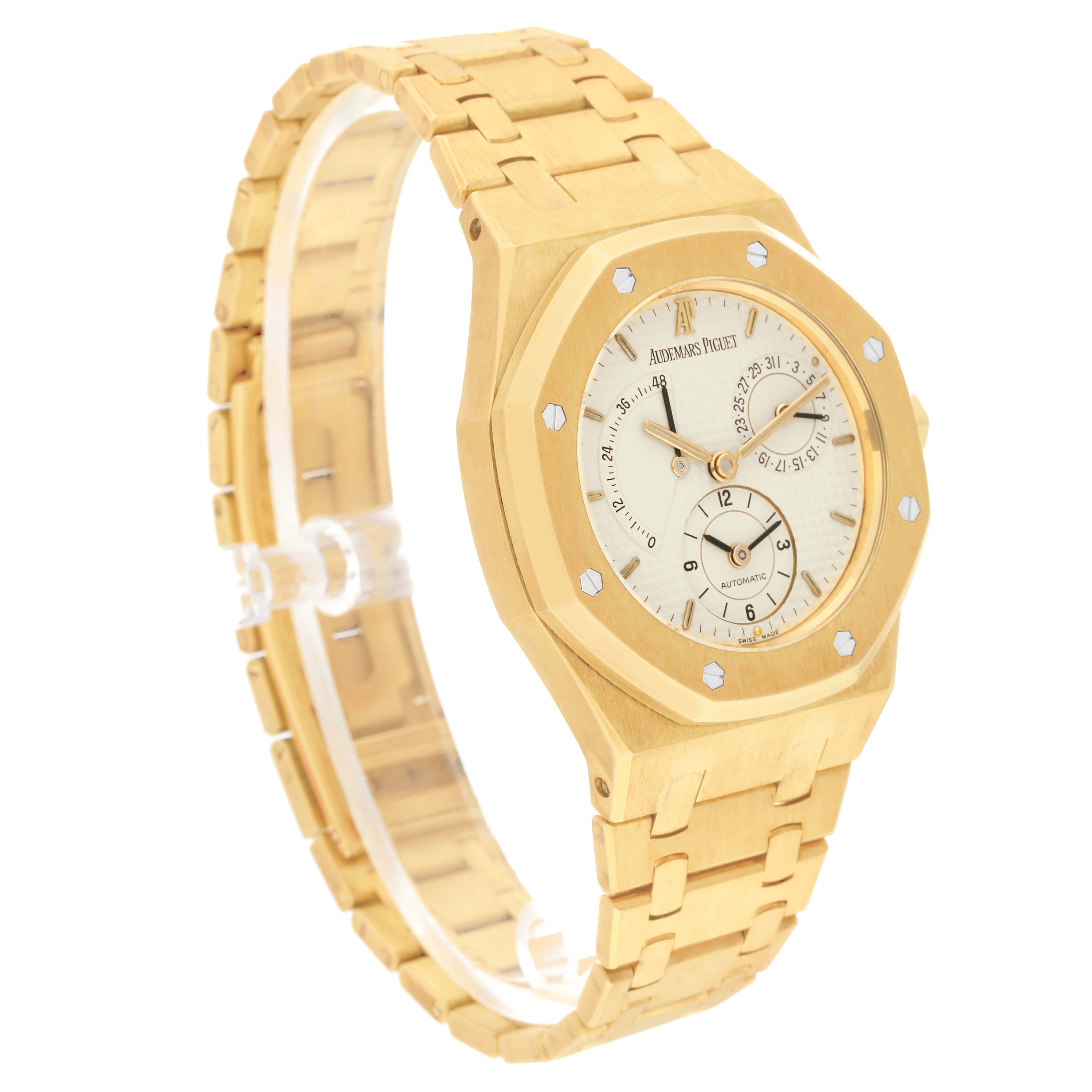 The image shows a side angle of the Audemars Piguet Royal Oak 25730BA Men's Yellow Gold Silver Dial 25730BA Men's Yellow Gold Silver Dial watch, highlighting its gold bracelet, octagonal bezel, and dial features.