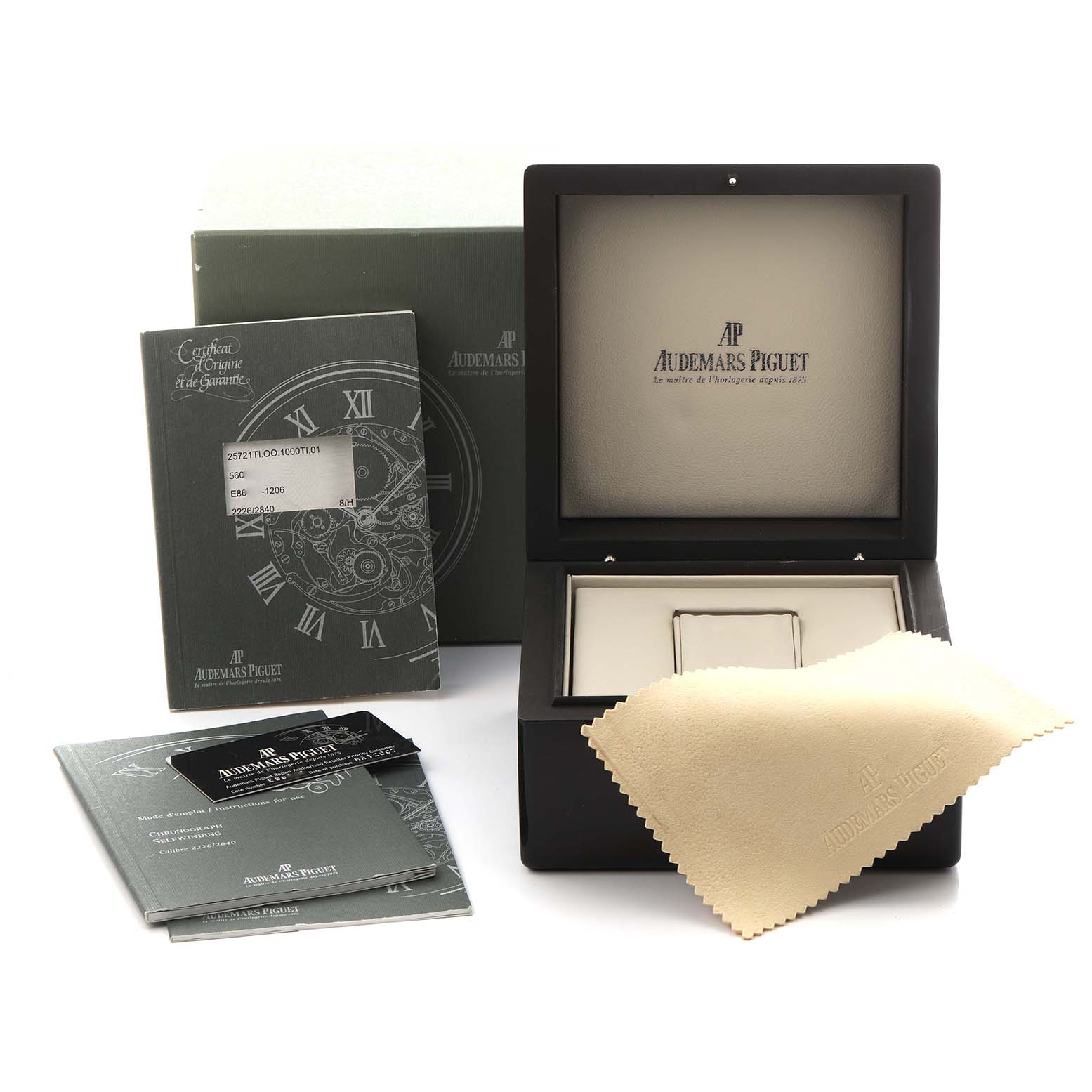 The image shows the packaging and accessories of an Audemars Piguet Royal Oak Offshore 25721TI.OO.10000TI.301 Men
s Titanium Grey Dial 25721TI.OO.10000TI.301 Men
s Titanium Grey Dial, including its box, papers, and cloth.