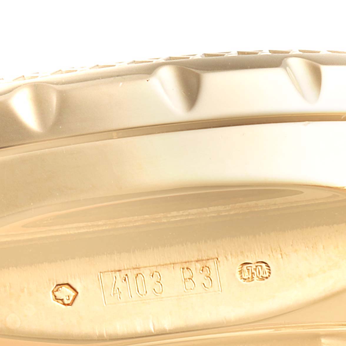 This image shows a close-up of the side and edge of the bezel of a Breitling Bentley K25362 Men's Yellow Gold Black Dial K25362 Men's Yellow Gold Black Dial watch, focusing on the serial number area.