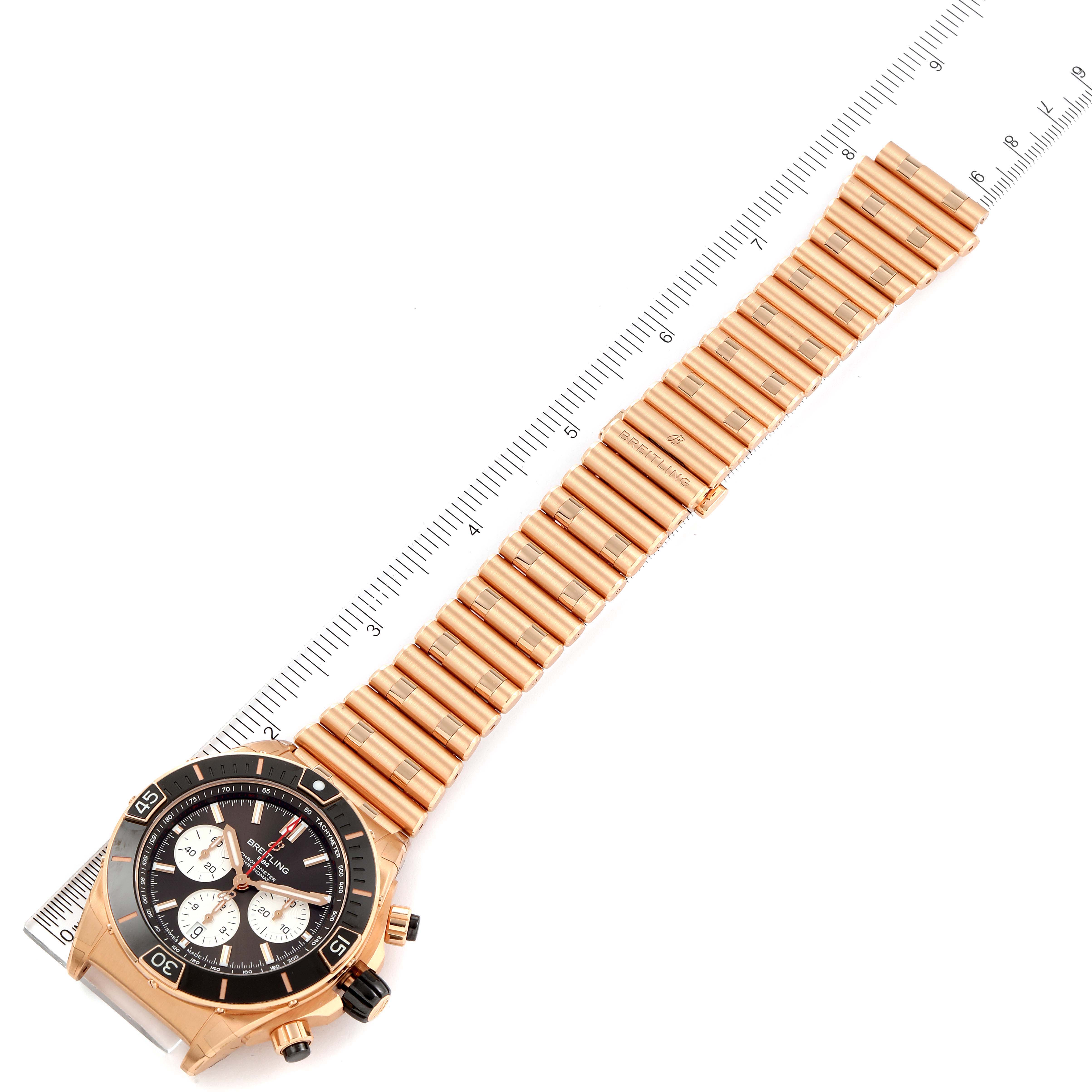 The image shows a Breitling Chronomat RB0136E31Q1R1 Men's Rose Gold Brown Dial RB0136E31Q1R1 Men's Rose Gold Brown Dial watch laid flat, with the entire watch and bracelet visible; a ruler is placed alongside it for measurement.