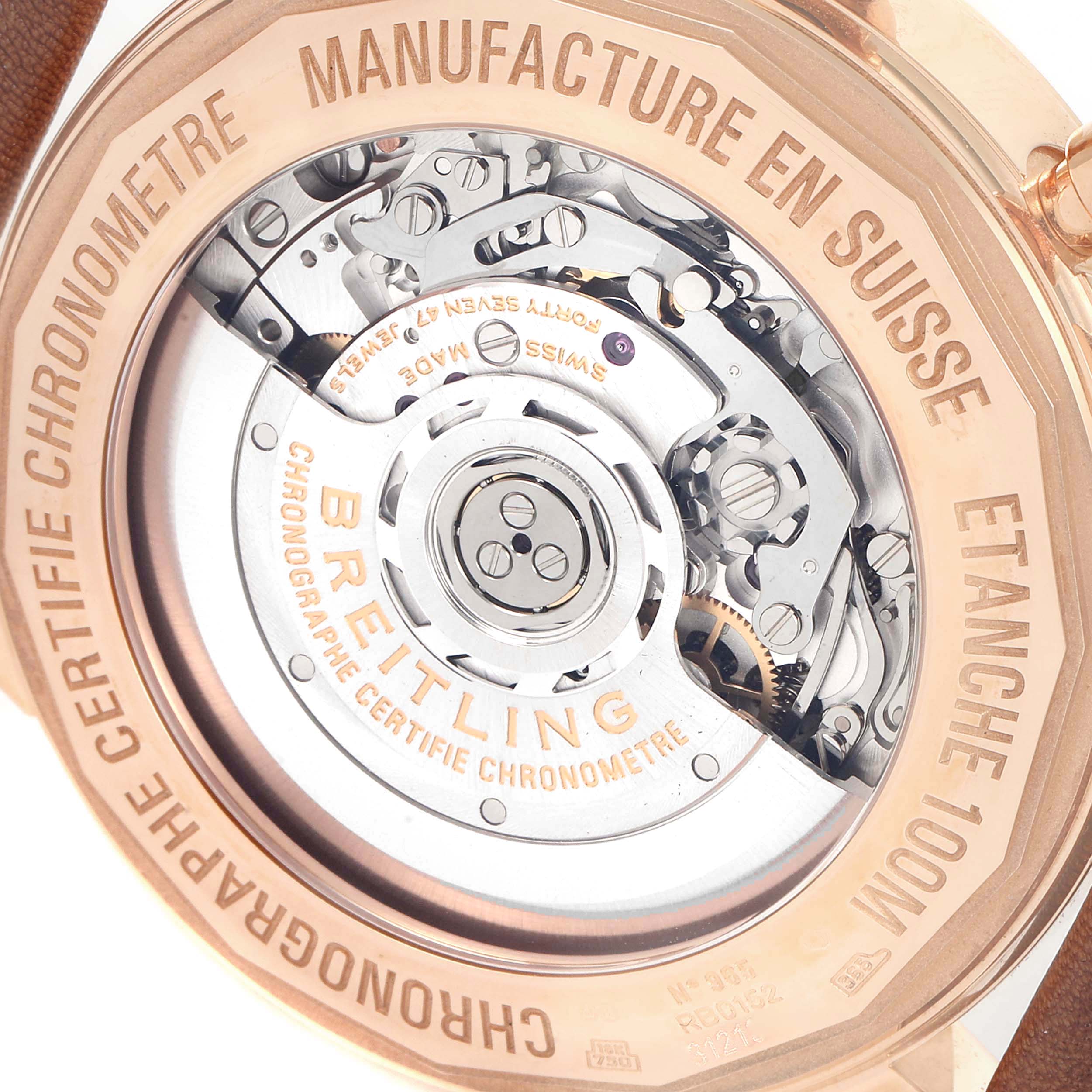 The image shows the back view of a Breitling Transocean RB0152 Men's Rose Gold Silver Dial RB0152 Men's Rose Gold Silver Dial watch, highlighting its intricate movement and "Manufacture en Suisse" engraving.