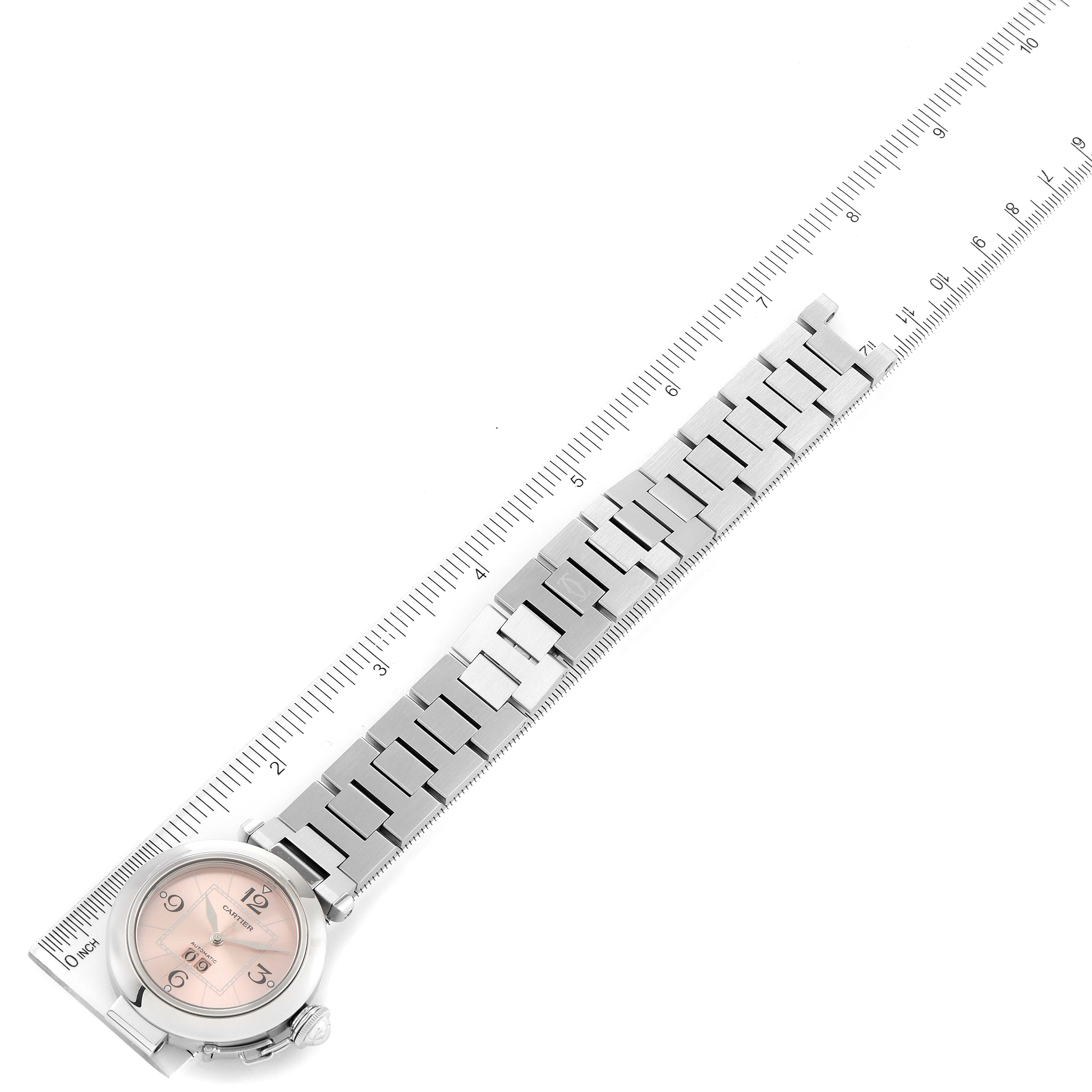 The image shows the Cartier Pasha W31058M7 Women's Stainless Steel Pink Dial W31058M7 Women's Stainless Steel Pink Dial watch with a full view of its silver metal bracelet against a ruler for scale.