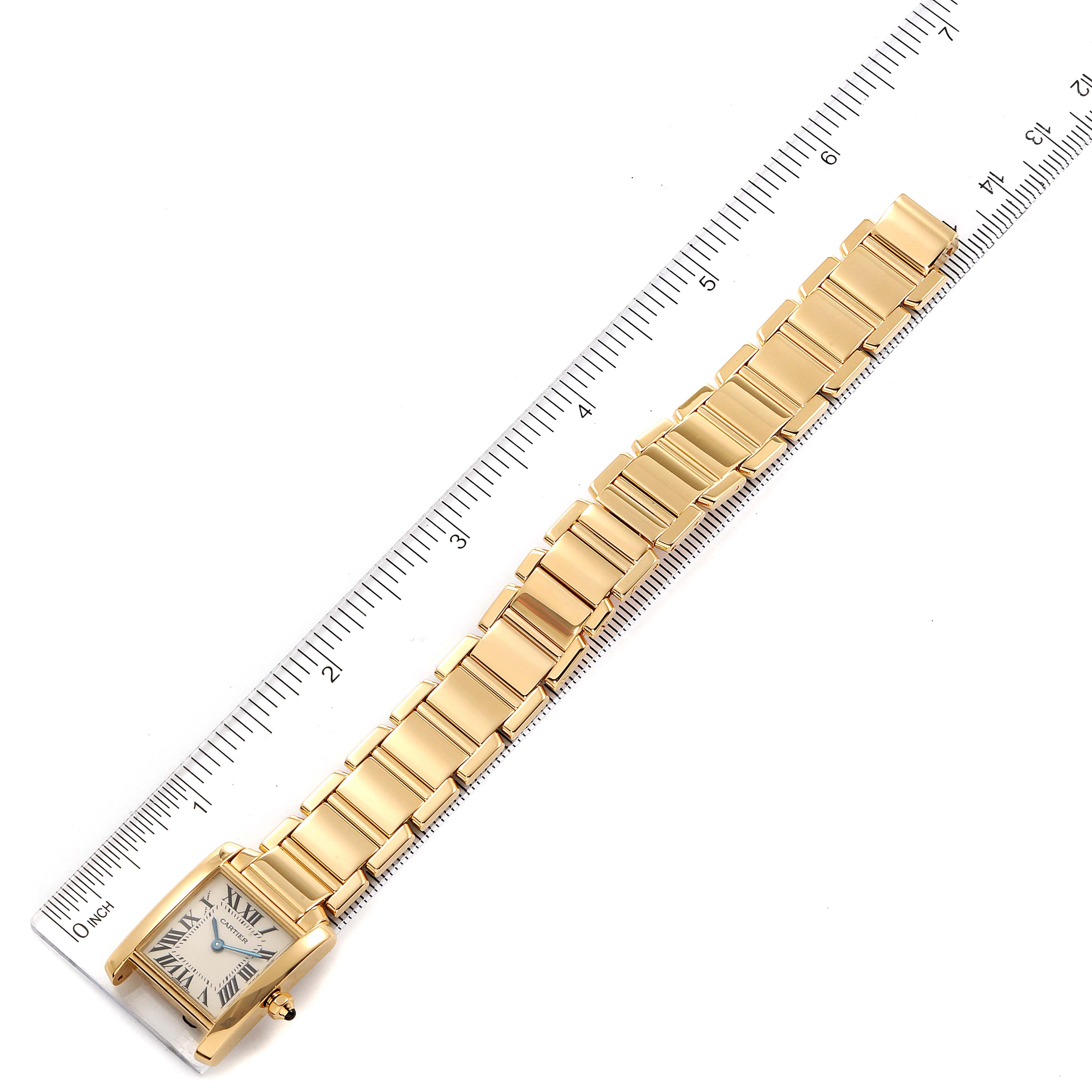 This Cartier Tank Francaise W50002N2 Women's Yellow Gold Silver Dial W50002N2 Women's Yellow Gold Silver Dial watch is positioned flat and aligned with a ruler, showcasing the band and face.