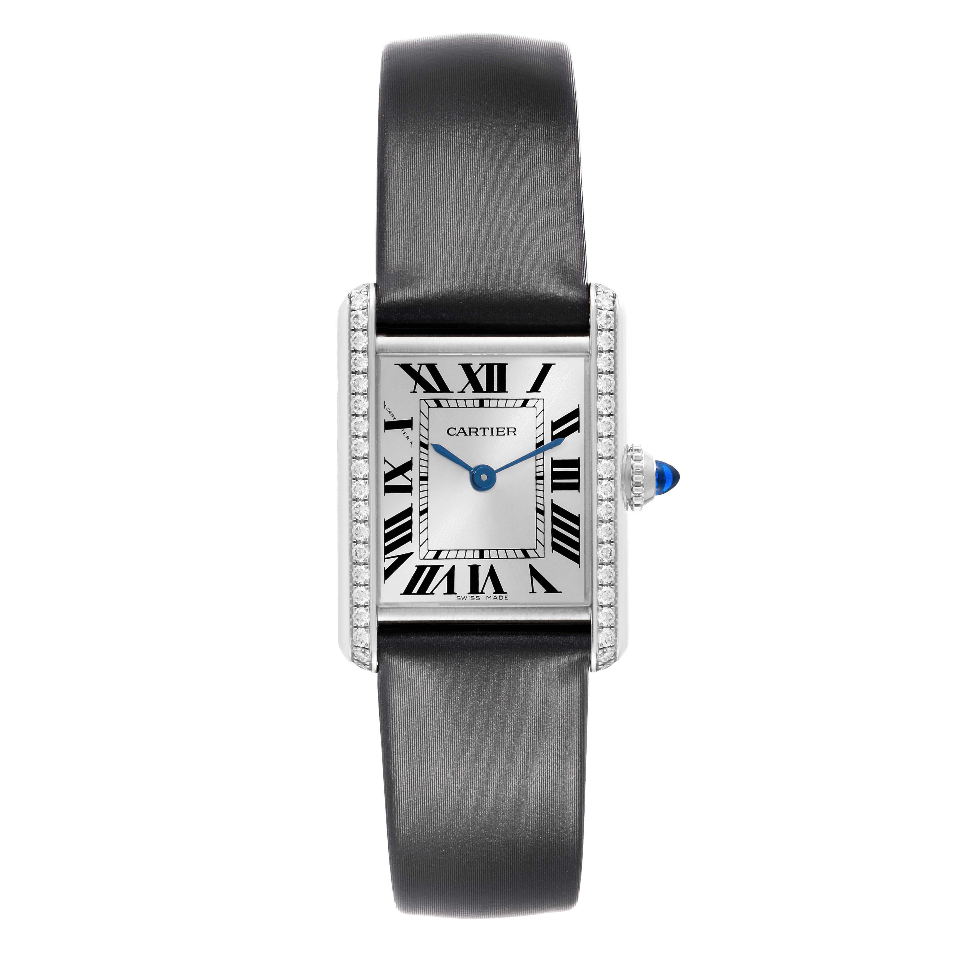 The Cartier Tank Must W4TA0016 Women's Stainless Steel Silver Dial watch is shown from a top view, displaying its face, Roman numerals, blue hands, and diamond-set bezel.