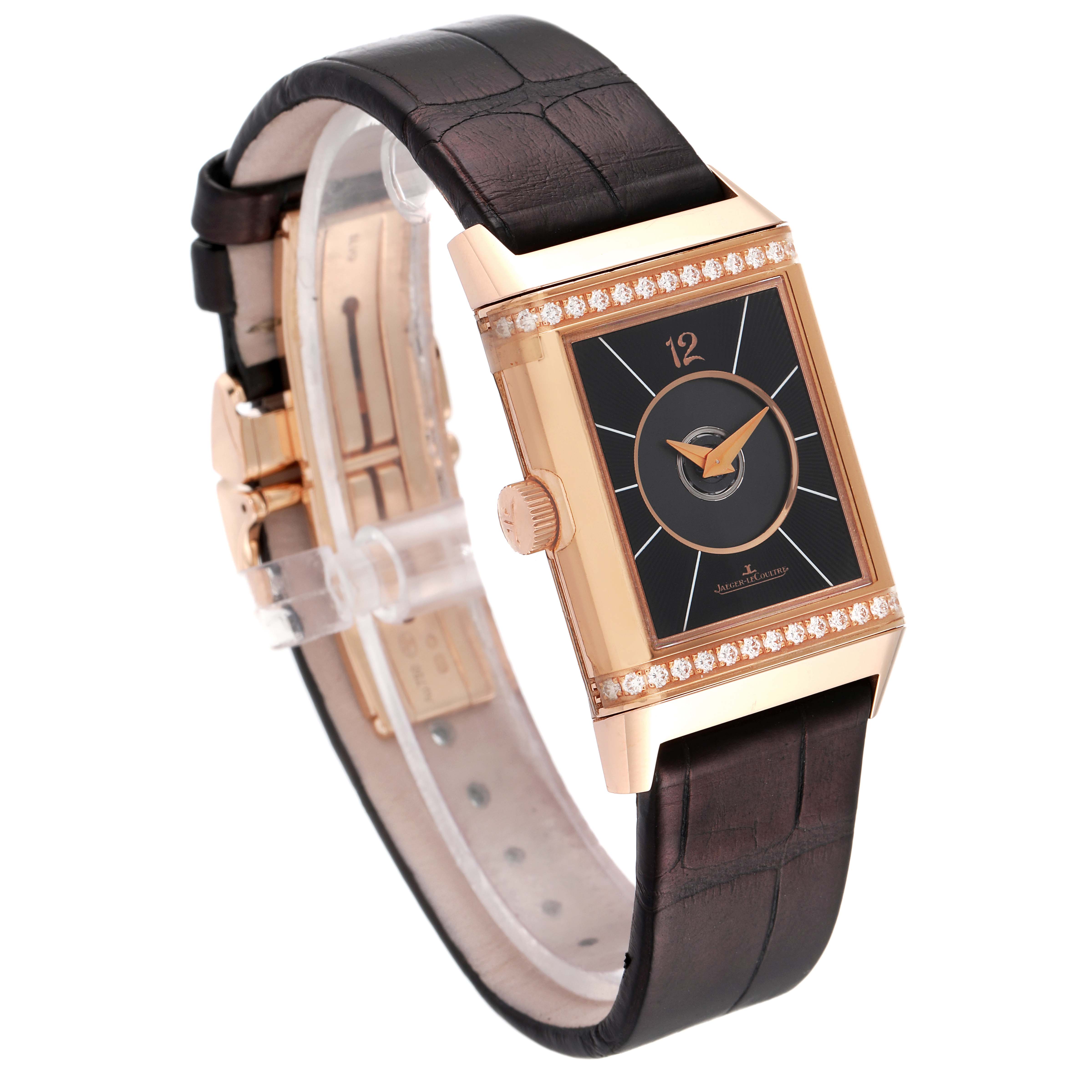 The image shows a Jaeger-LeCoultre Reverso watch from a three-quarter angle, highlighting the dial, crown, leather strap, and diamond-set case.