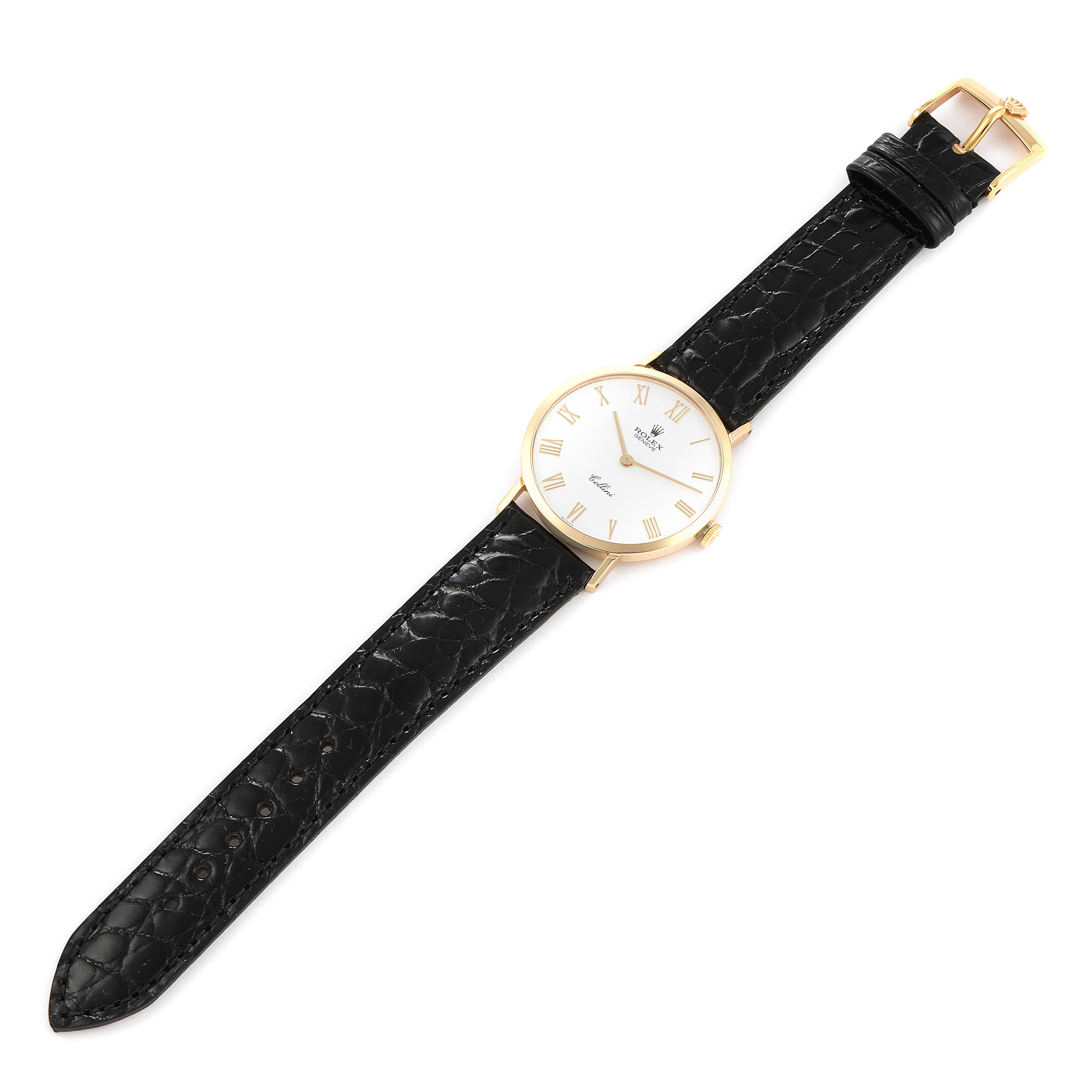 The Rolex Cellini 4112 Men's Yellow Gold White Dial 4112 Men's Yellow Gold White Dial watch is shown from a top-down angle, featuring its black leather strap and gold watch face with Roman numerals.