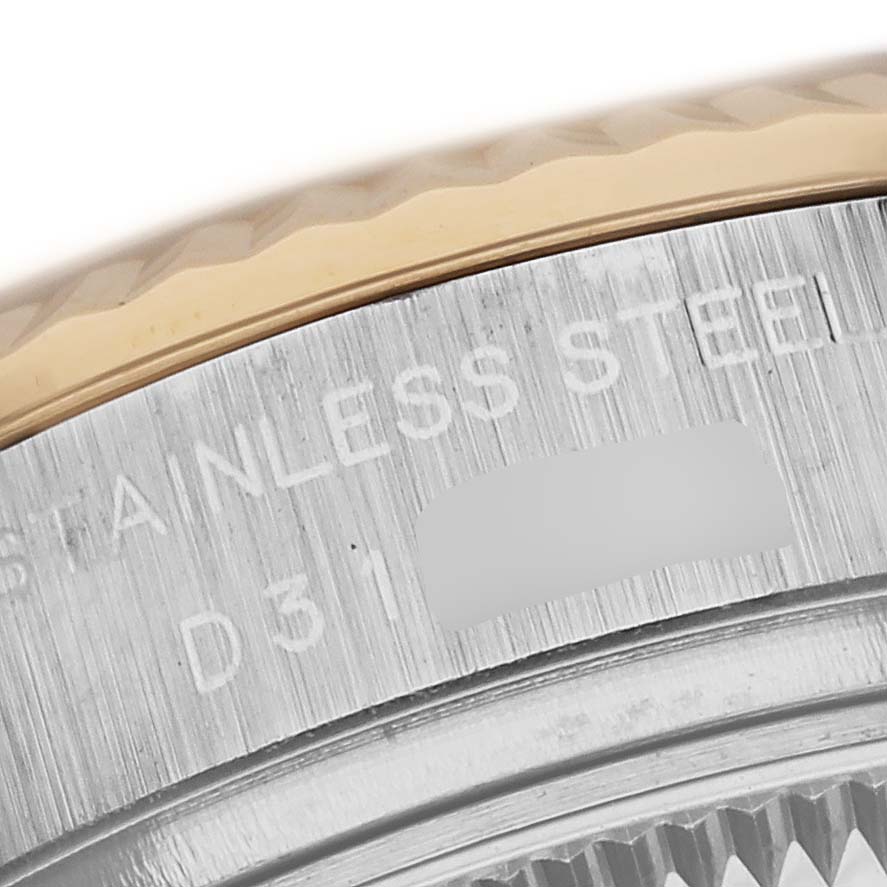 The image shows a close-up of the bezel and part of the case back of the Rolex Datejust 179173 Women's Steel and Gold (two tone) Silver Dial 179173 Women's Steel and Gold (two tone) Silver Dial watch, featuring the "STAINLESS STEEL" engraving.