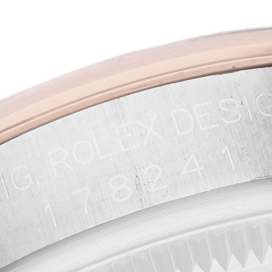 This image shows a close-up of the engraved bezel edge and part of the case of a Rolex Mid-Size 178241 Women's Steel and Gold (two tone) White Dial 178241 Women's Steel and Gold (two tone) White Dial watch.